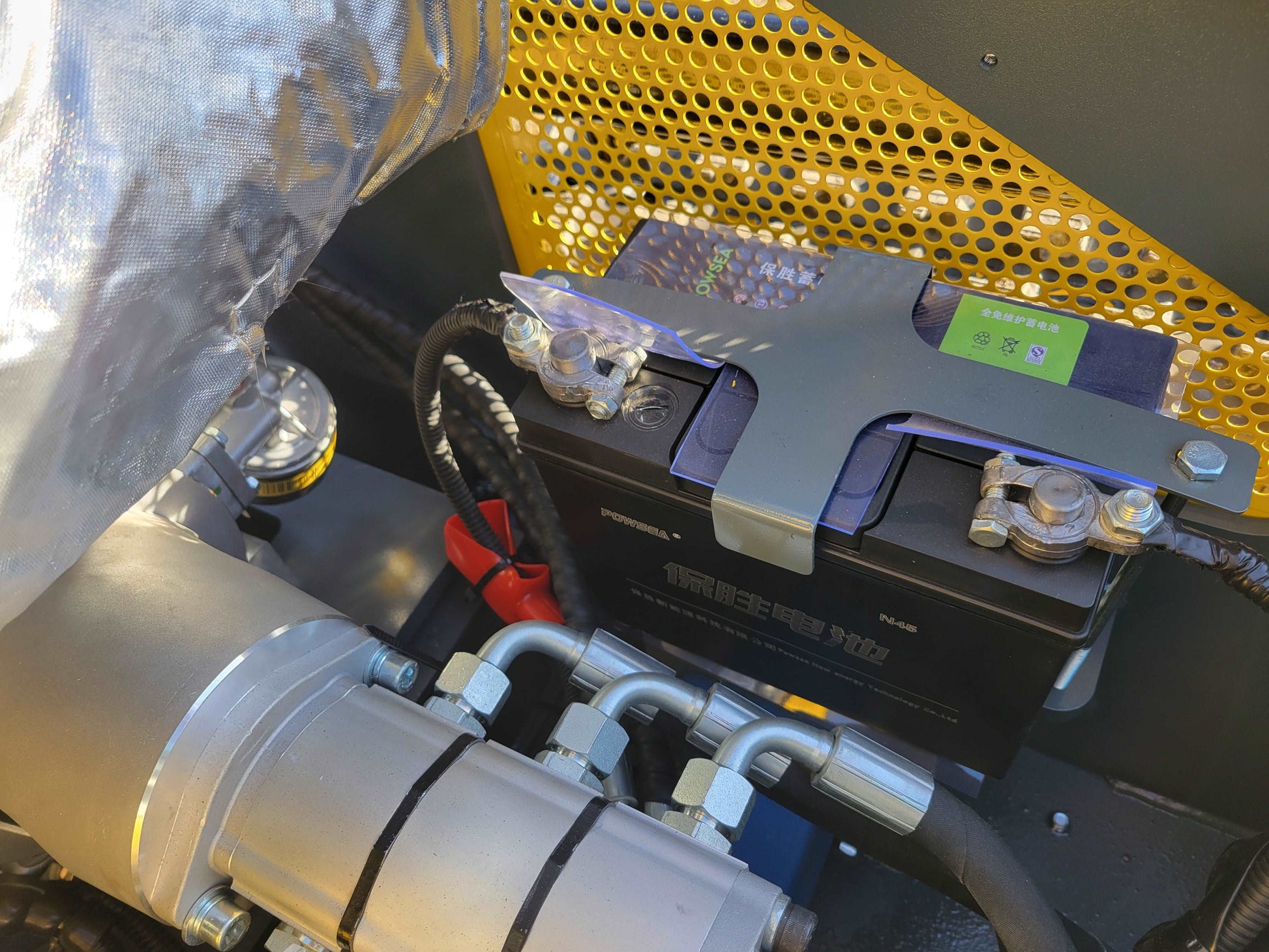 Close-up view of the battery and hydraulic connections inside JoyT5 JT5SSTM3 mini skid steer loader