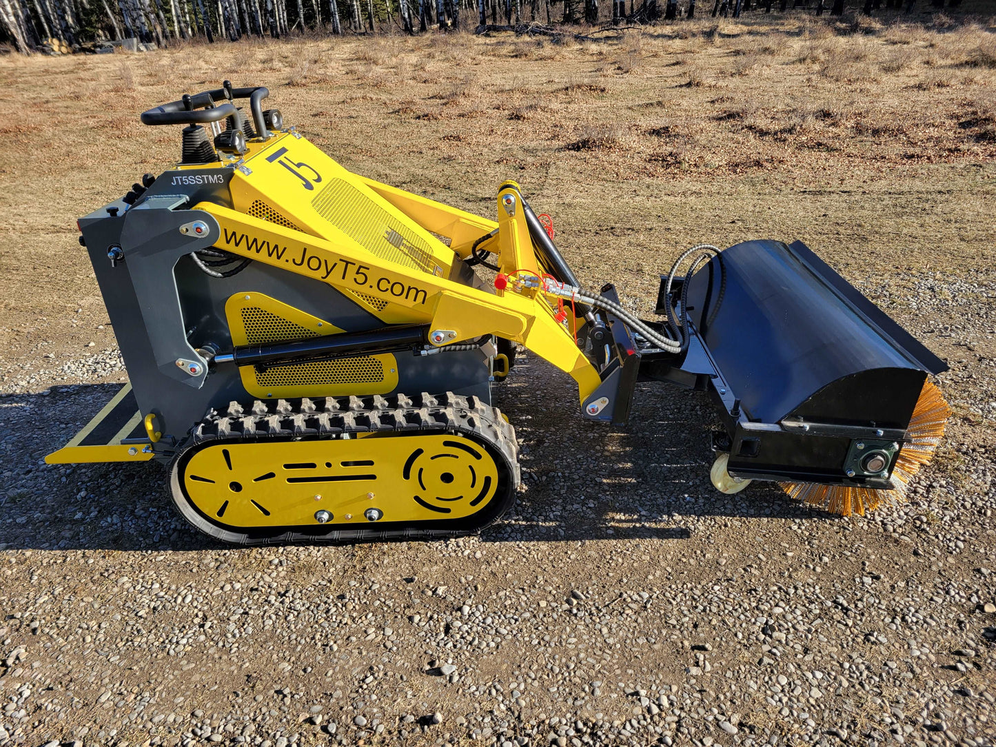 JJoyT5 JT5SSTM3 mini skid steer loader with hydraulic sweeper attachment on gravel surface