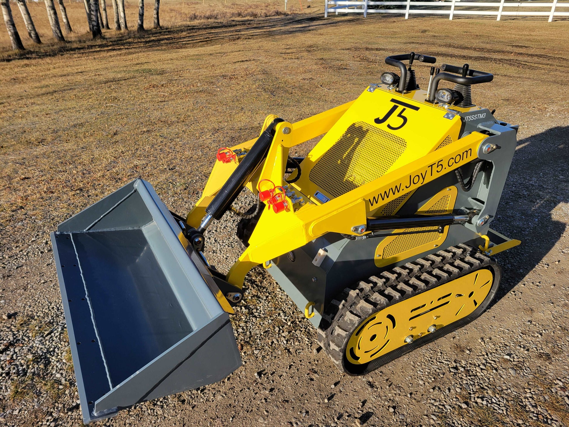 JoyT5 JT5SSTM3 mini tracked skid steer with front bucket attachment shown from angled view for landscaping and construction work in Canada