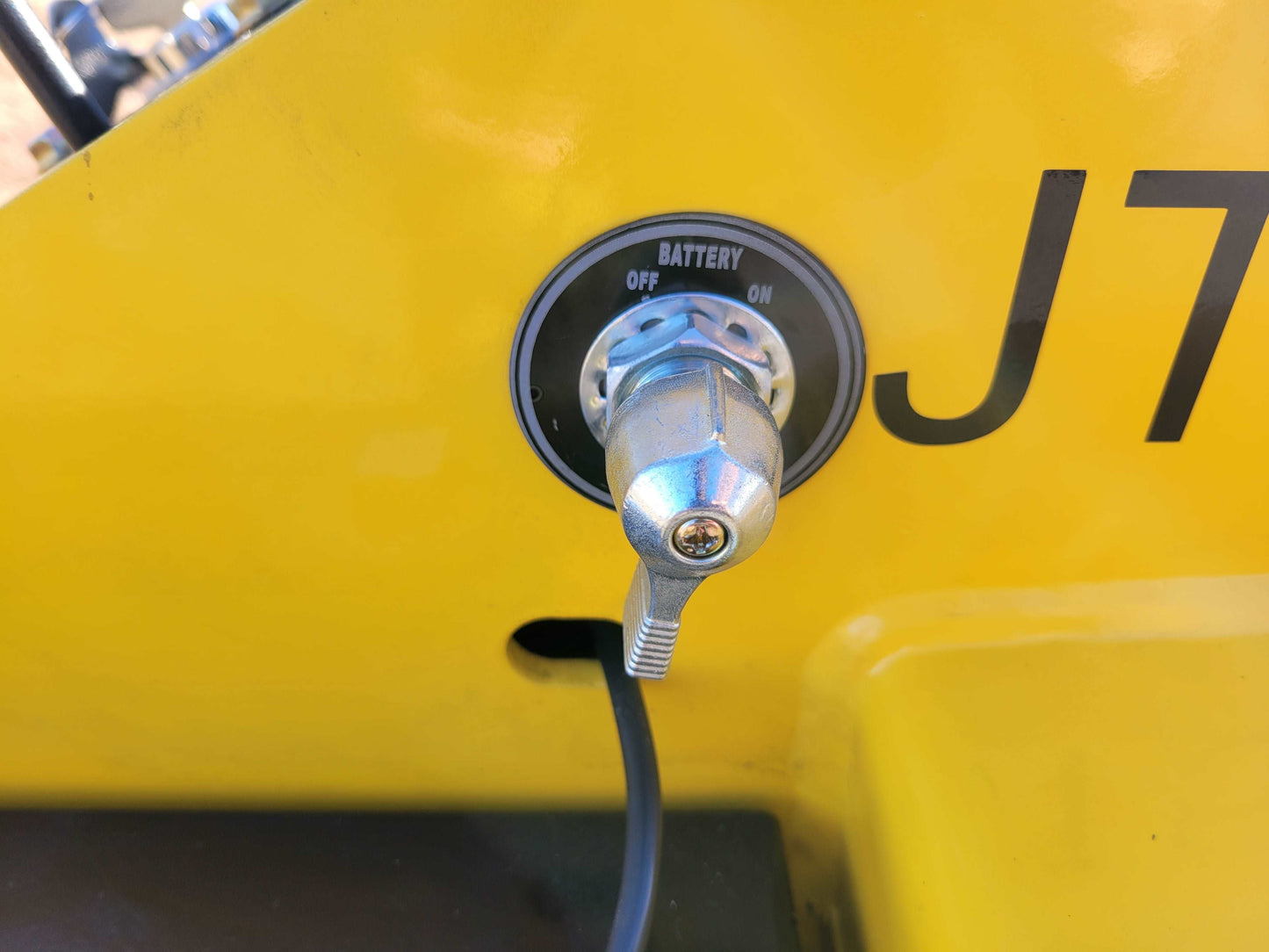 Battery disconnect switch with ON and OFF control on JoyT5 JT5SSTM4 mini skid steer side panel.