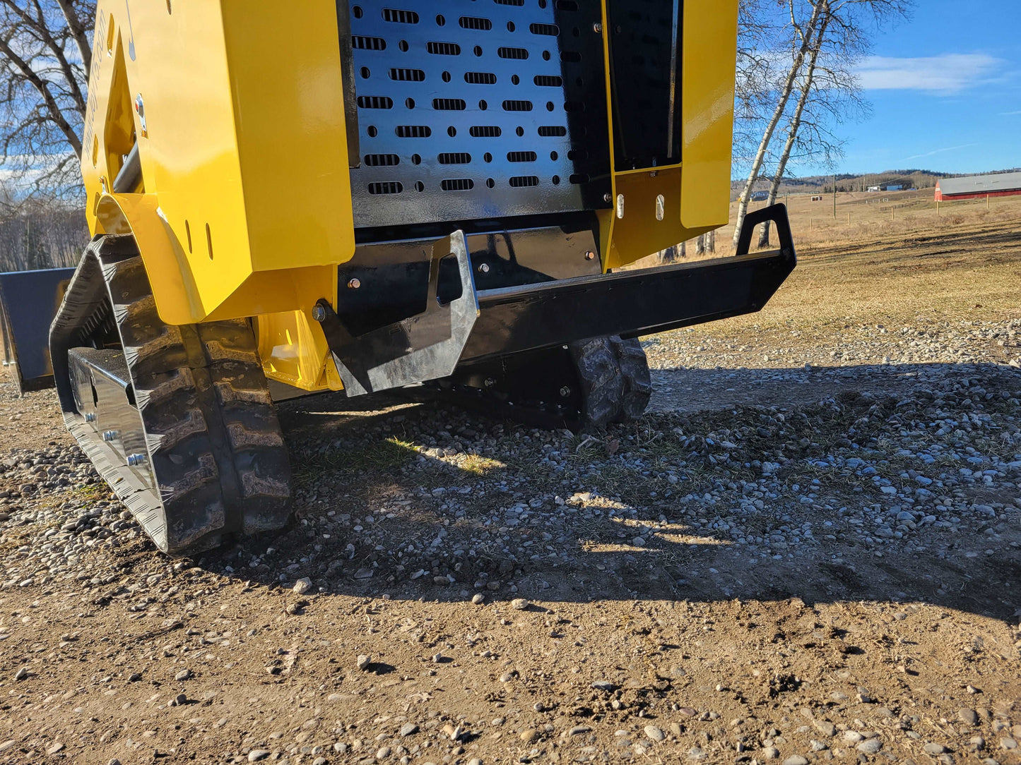 Rear view of JoyT5 JT5SSTM4 mini skid steer loader with rubber tracks, counterweight, and heavy-duty steel frame design.