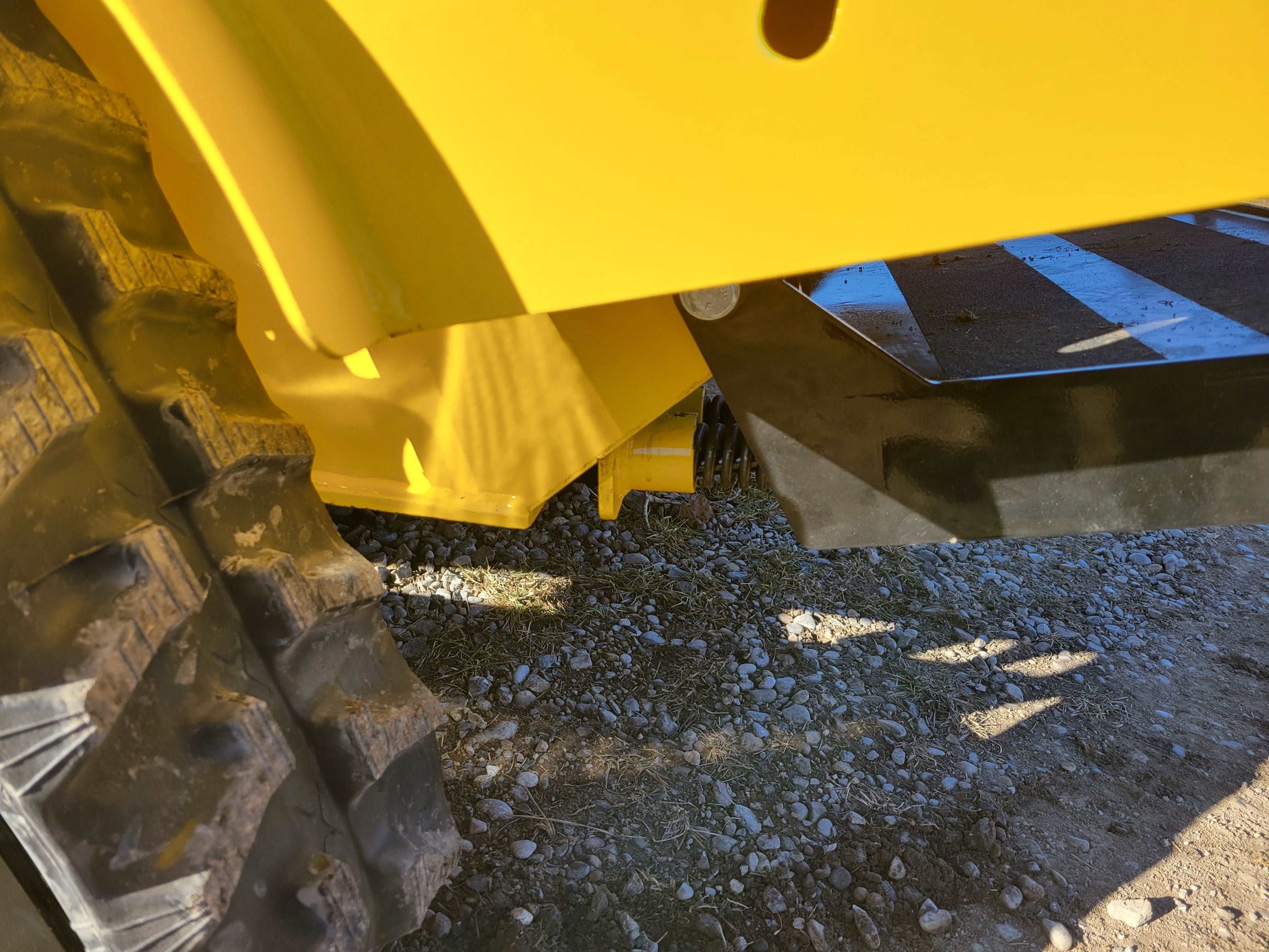 JoyT5 JT5SSTM4 tracked mini skid steer 25 HP underbody protection in Canada showing reinforced steel belly guard and rubber track clearance for diesel stand on loader