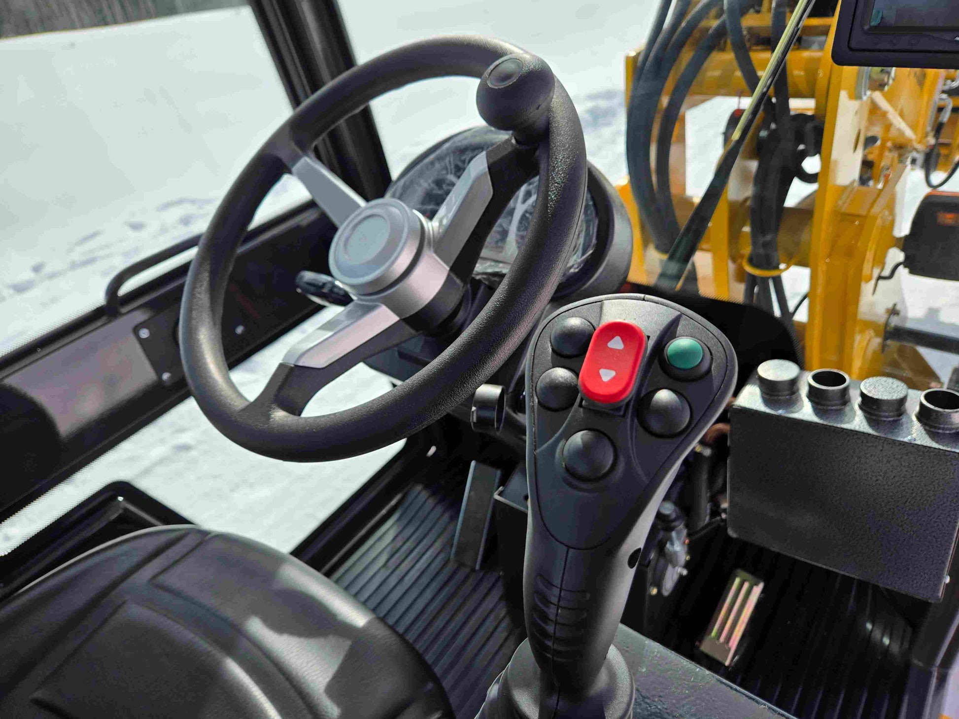 JT5WL1000 Compact Wheel Loader 1 Ton 2200 lbs for Sale Canada steering wheel and multifunction control joystick inside operator cabin.