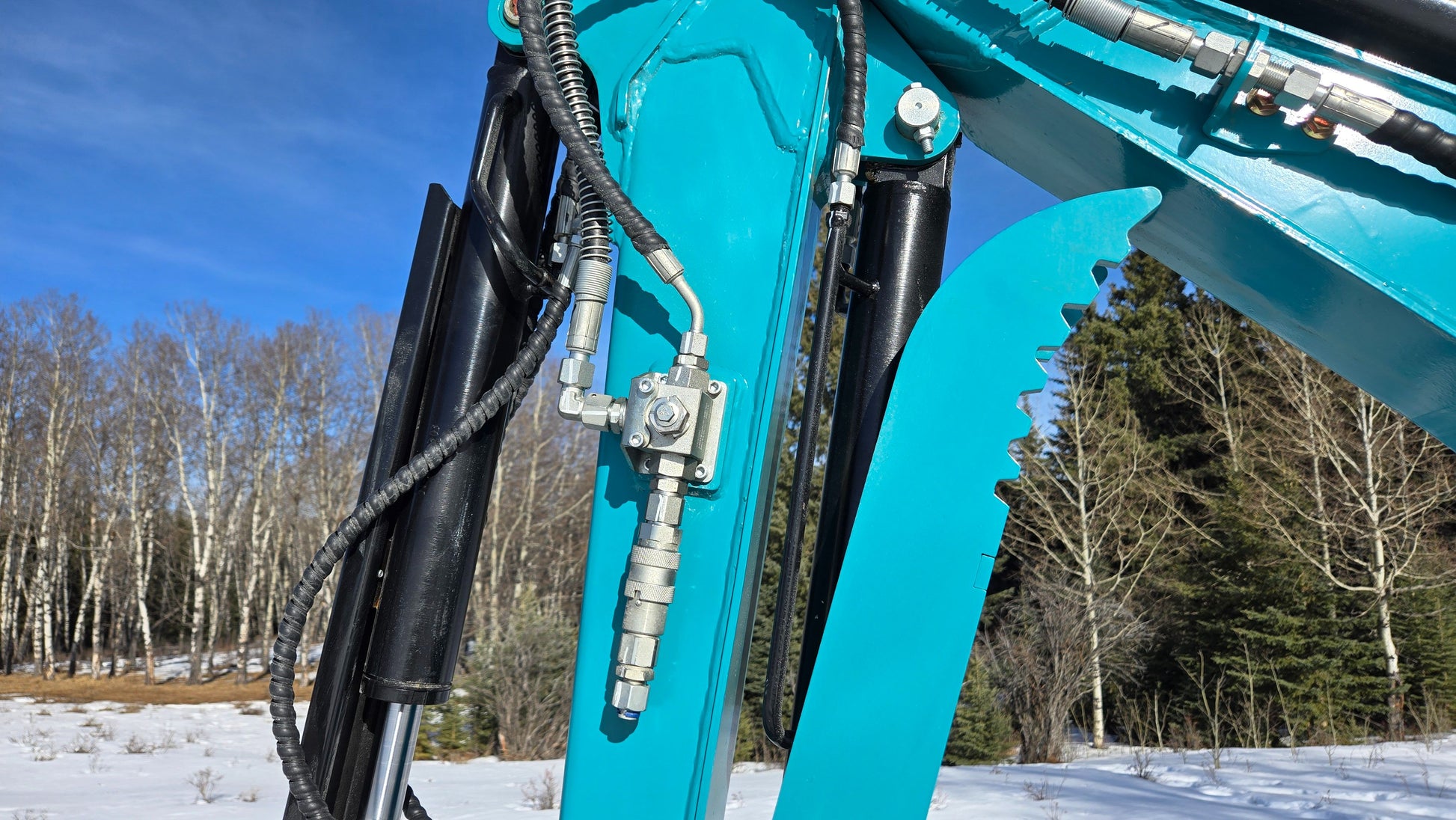 Close-up of JoyT5 mini excavator hydraulic system with auxiliary quick coupler and hoses.
