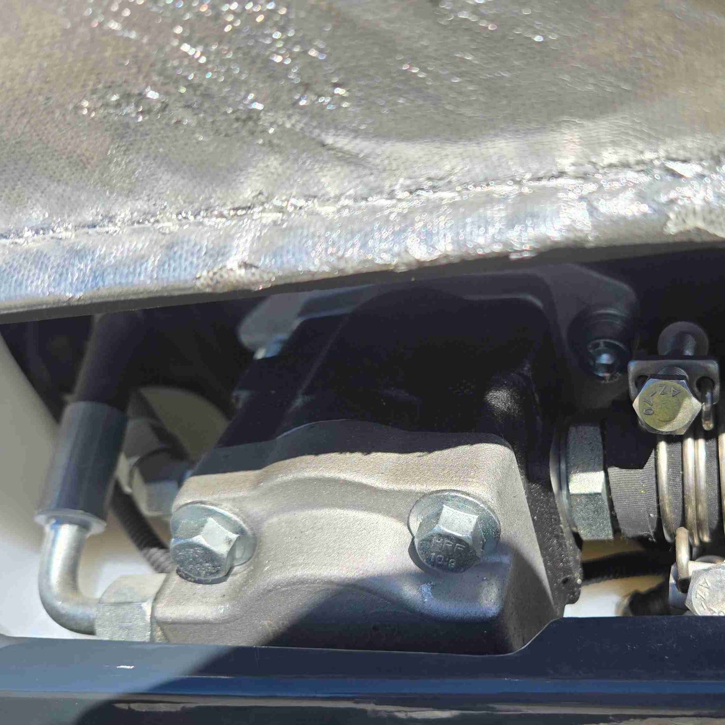 Close-up view of JoyT5 mini excavator hydraulic pump mounting with heavy-duty bolts and secure connections, highlighting durable construction for reliable performance in compact excavation work