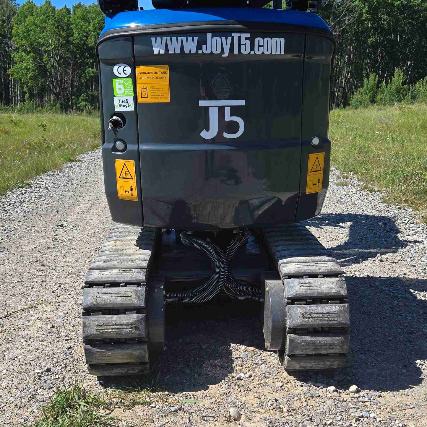 Rear view of JoyT5 mini excavator showing rubber tracks, protected undercarriage and J5 branding, highlighting compact design, stability and durability for landscaping, construction and utility work across Canada