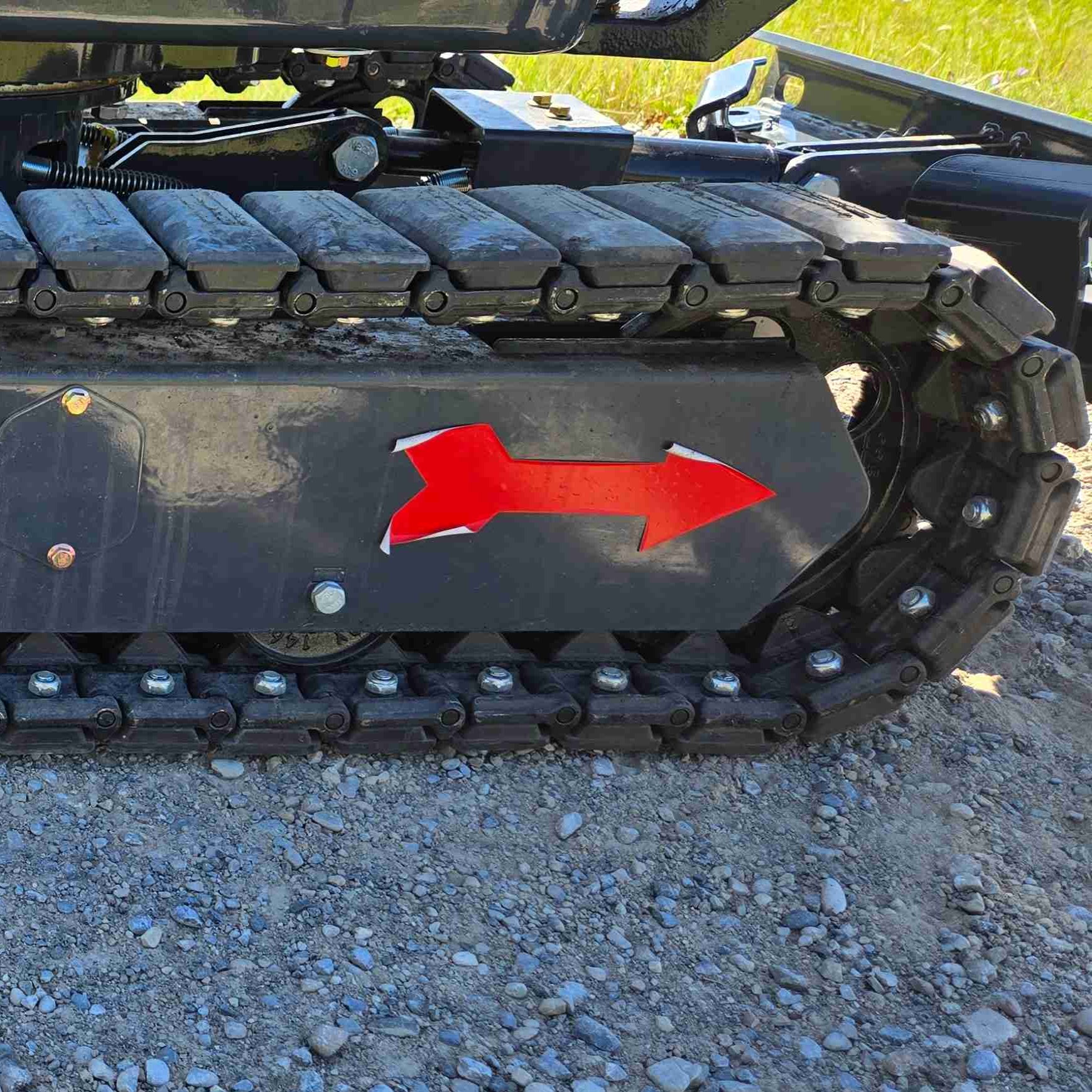 Close-up view of JoyT5 mini excavator rubber track and undercarriage with directional arrow indicator, showing heavy-duty track links designed for smooth movement, stability and durability on gravel, soil and construction sites across Canada