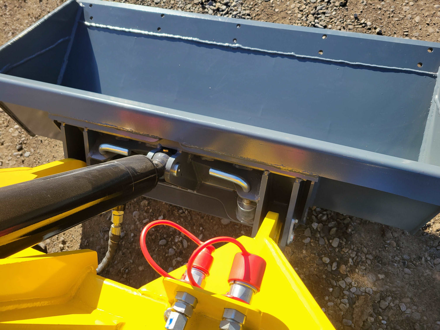JoyT5 mini skid steer bucket interior showing hydraulic tilt cylinder and steel construction at a Canada worksite