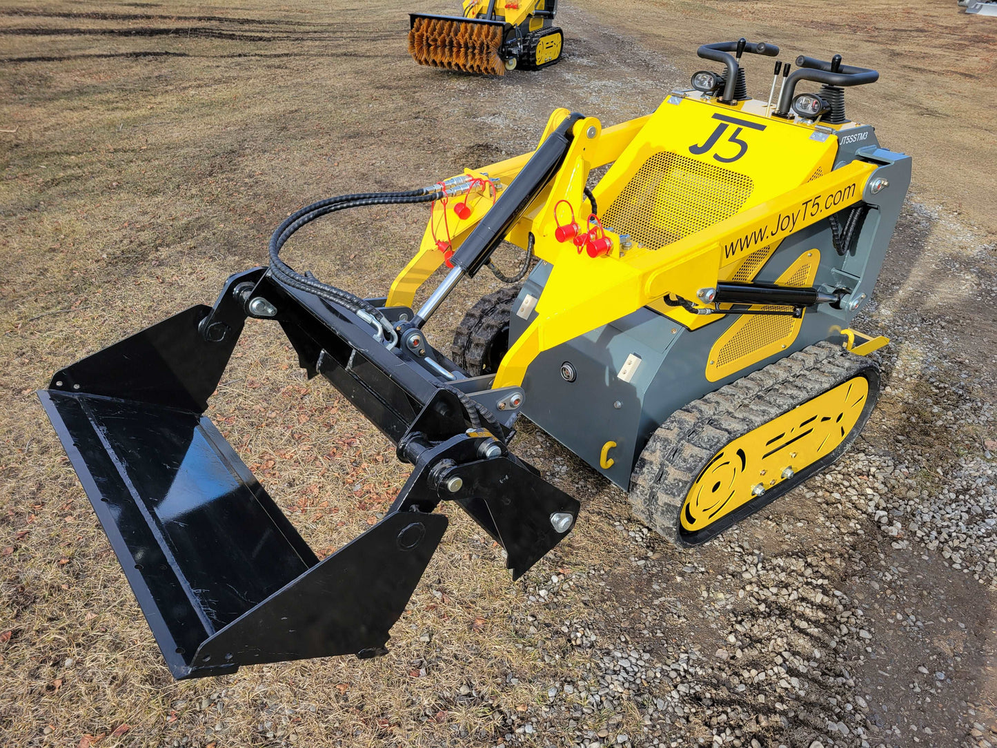 Front view of JoyT5 mini skid steer loader with a raised bucket attachment, designed for compact construction and landscaping projects.