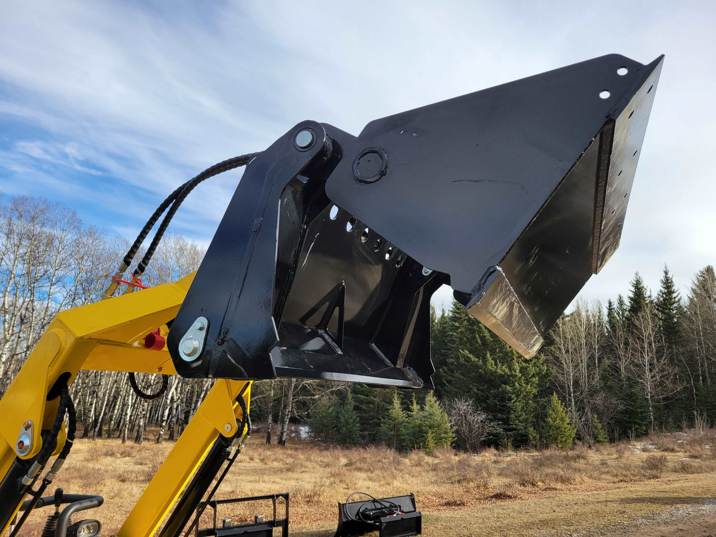 Close-up view of JoyT5 mini skid steer loader bucket and hydraulic arms, showing heavy-duty construction for digging and lifting tasks.