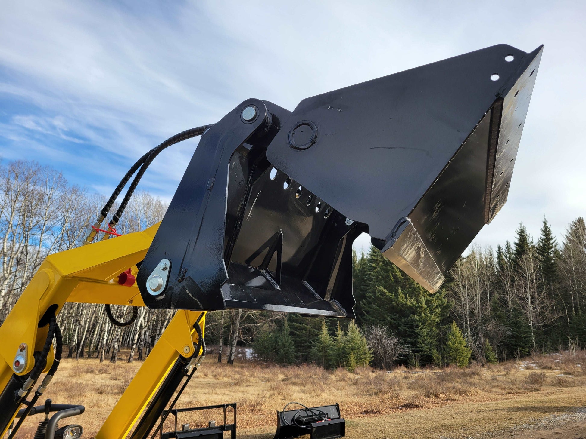 Close-up view of JoyT5 mini skid steer loader bucket and hydraulic arms, showing heavy-duty construction for digging and lifting tasks.