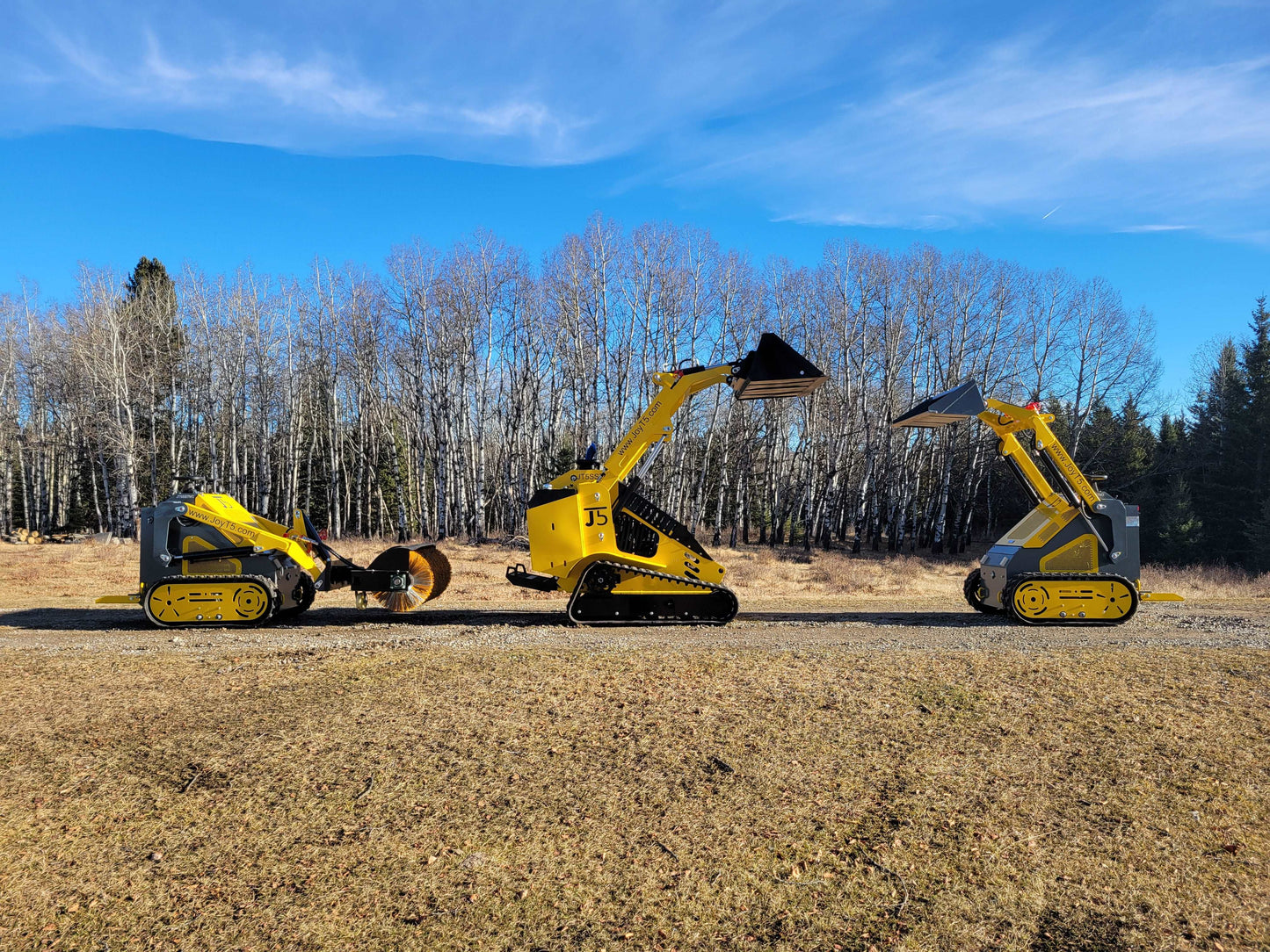 Three JoyT5 mini skid steer loaders side by side with buckets and a sweeper attachment, showcasing tracked and wheeled models outdoors.