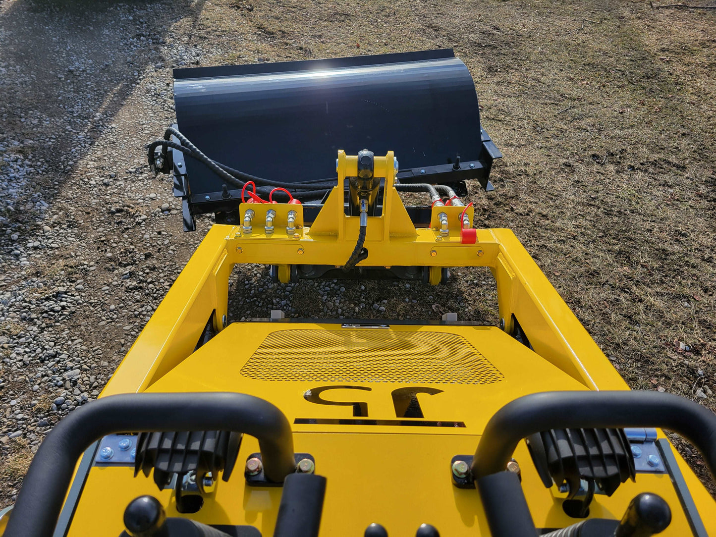 JoyT5 mini skid steer operator view showing front bucket and hydraulic arms at a Canada worksite