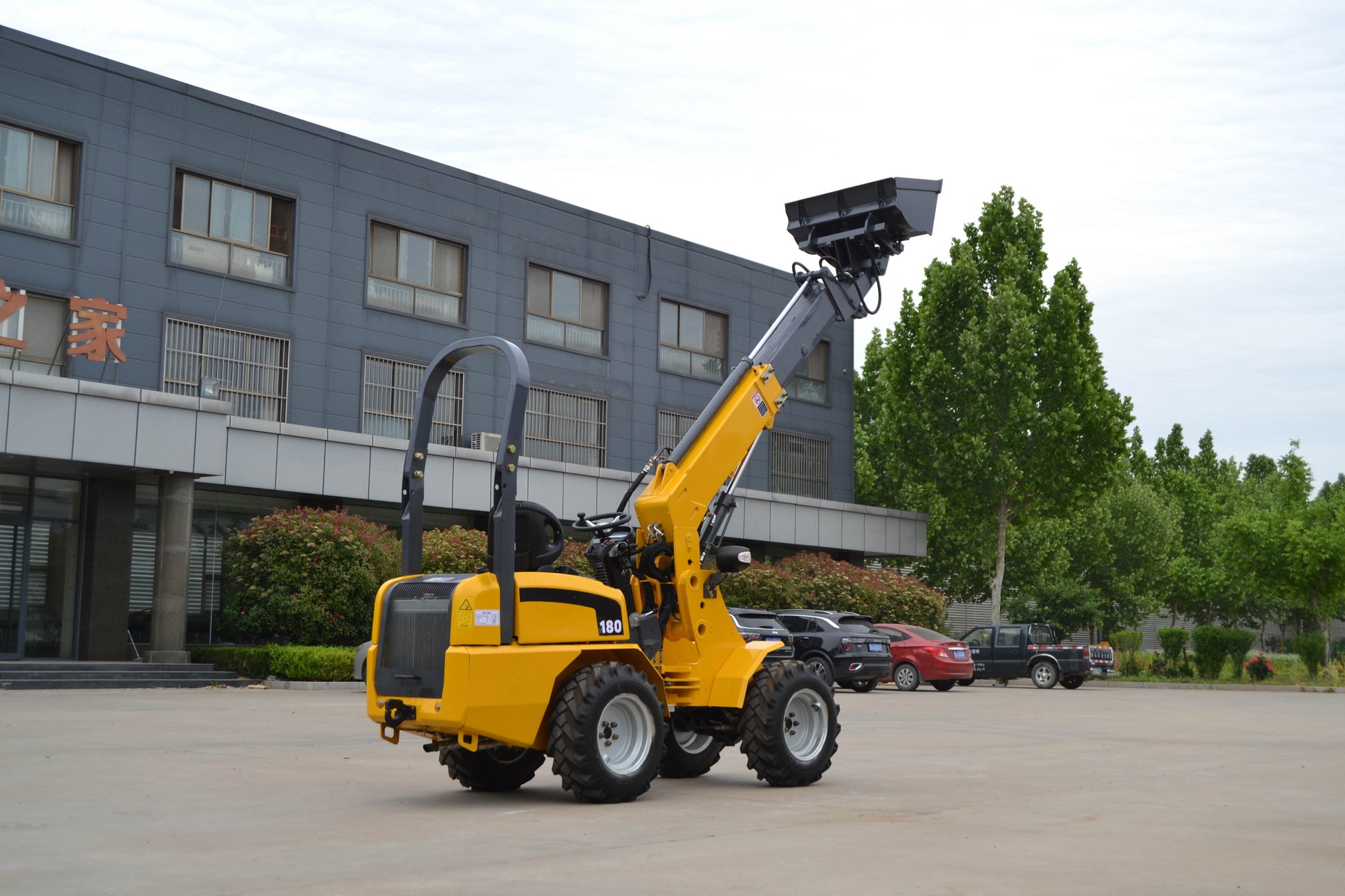 JoyT5 180 mini telescopic wheel loader lifted boom with bucket outdoor demonstration, ideal for construction and landscaping projects in Canada.