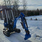 Mini excavator Rippa R10 working on a snowy road in Canada, blue JoyT5 machine parked outdoors in winter landscape.