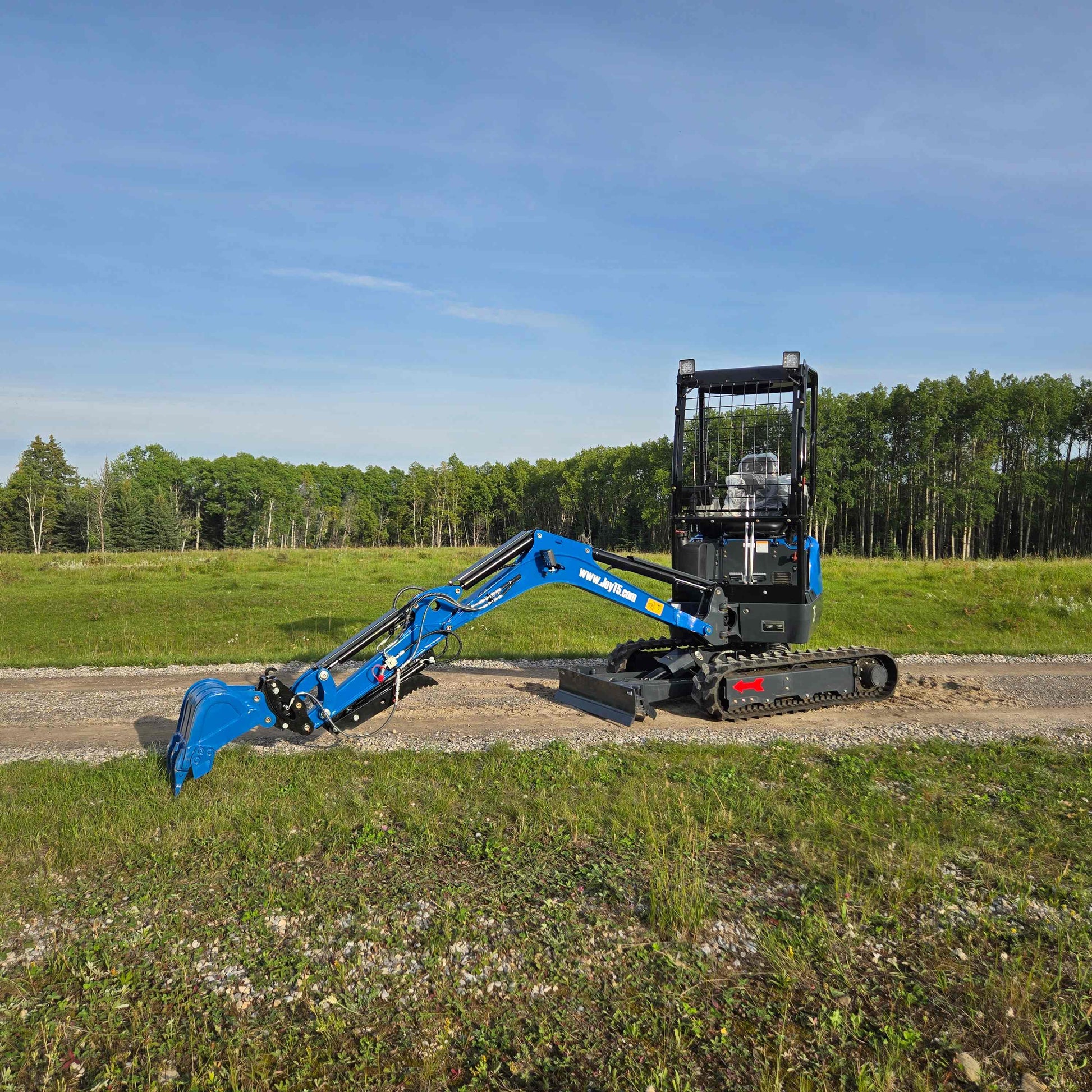 Front side view of JoyT5 Rippa R18 Mini Excavator with extended boom and digging bucket reaching the ground on a gravel path