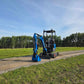 Front view of JoyT5 Rippa R18 Mini Excavator with bucket, hydraulic arm, and operator cabin on a gravel path