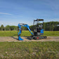 Side view of JoyT5 Rippa R18 Mini Excavator with bucket resting on ground, rubber tracks and front blade visible on gravel path