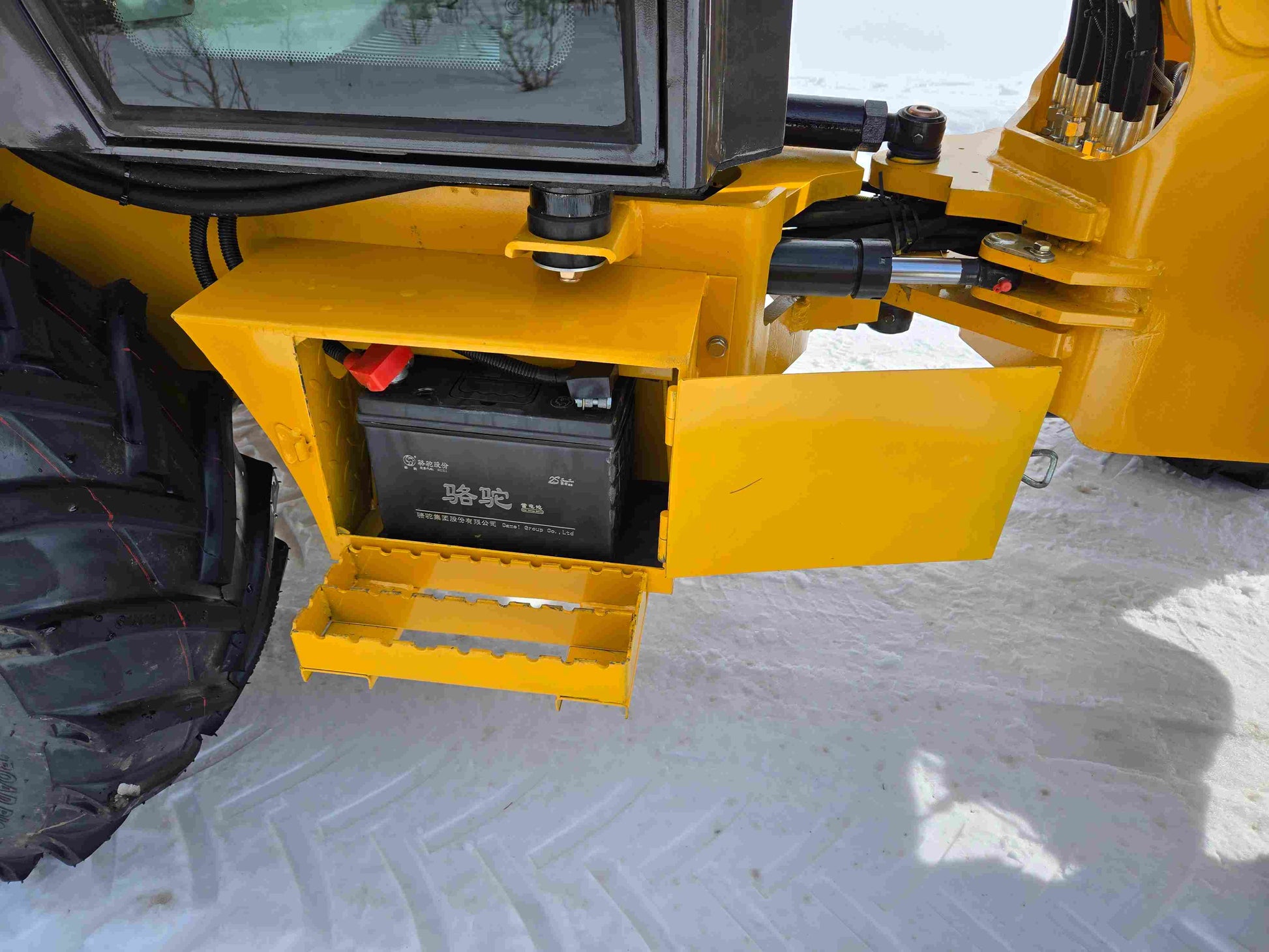 JT5 wheel loader battery compartment with step ladder open showing installed battery.