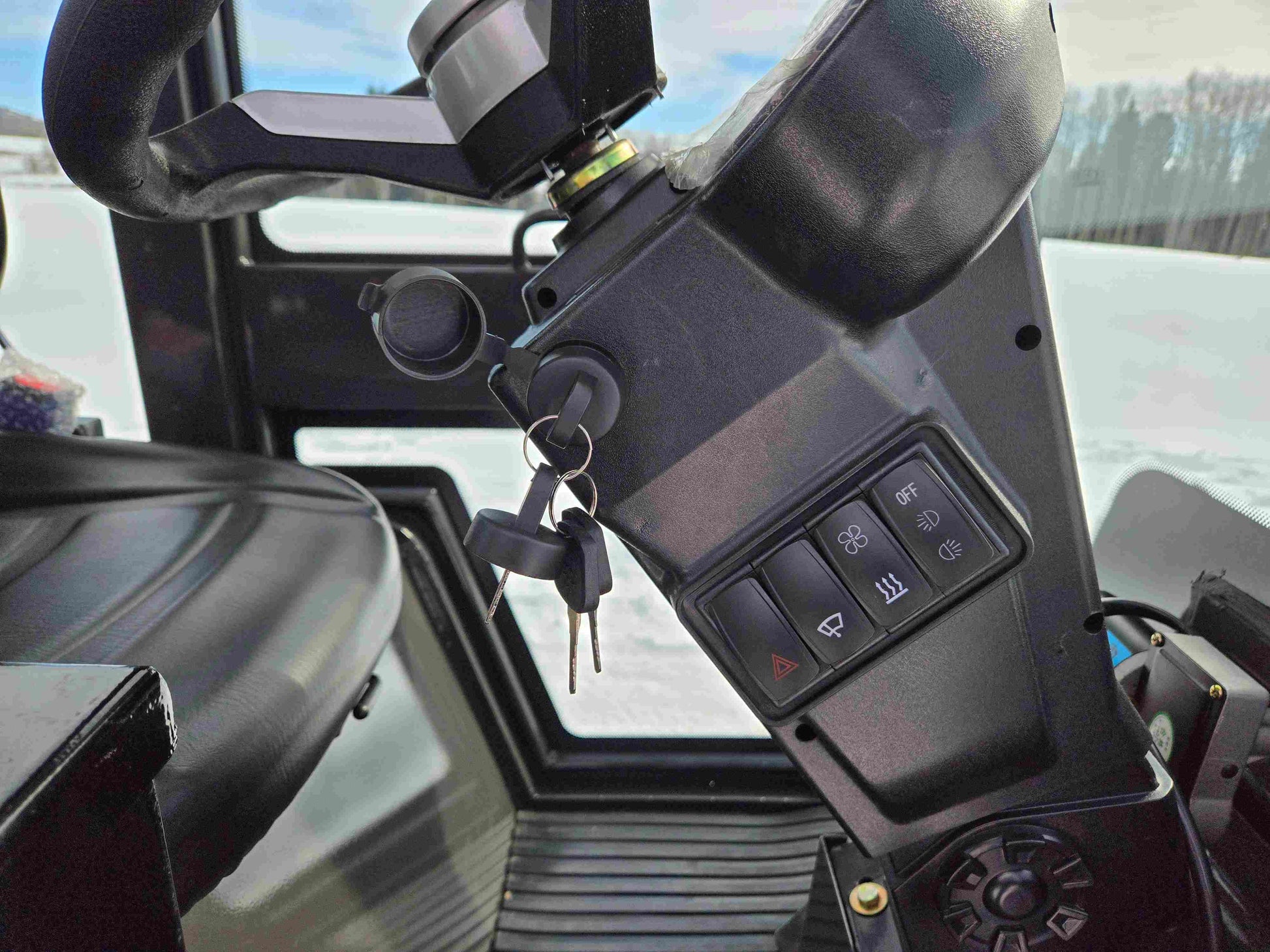 Close-up view of JT5 wheel loader cabin dashboard showing ignition key switch and control buttons.