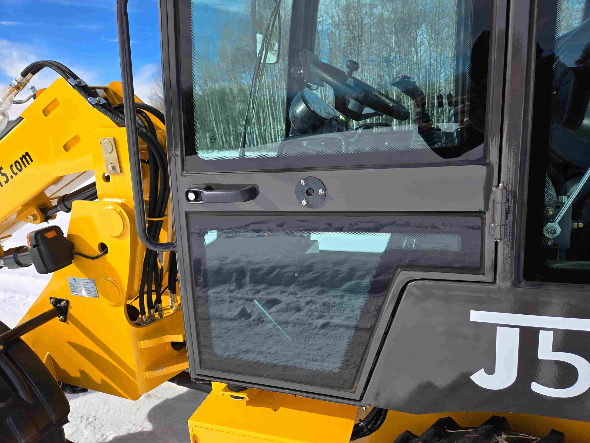 JT5 wheel loader cabin side door with glass window, steering wheel and control levers visible inside.