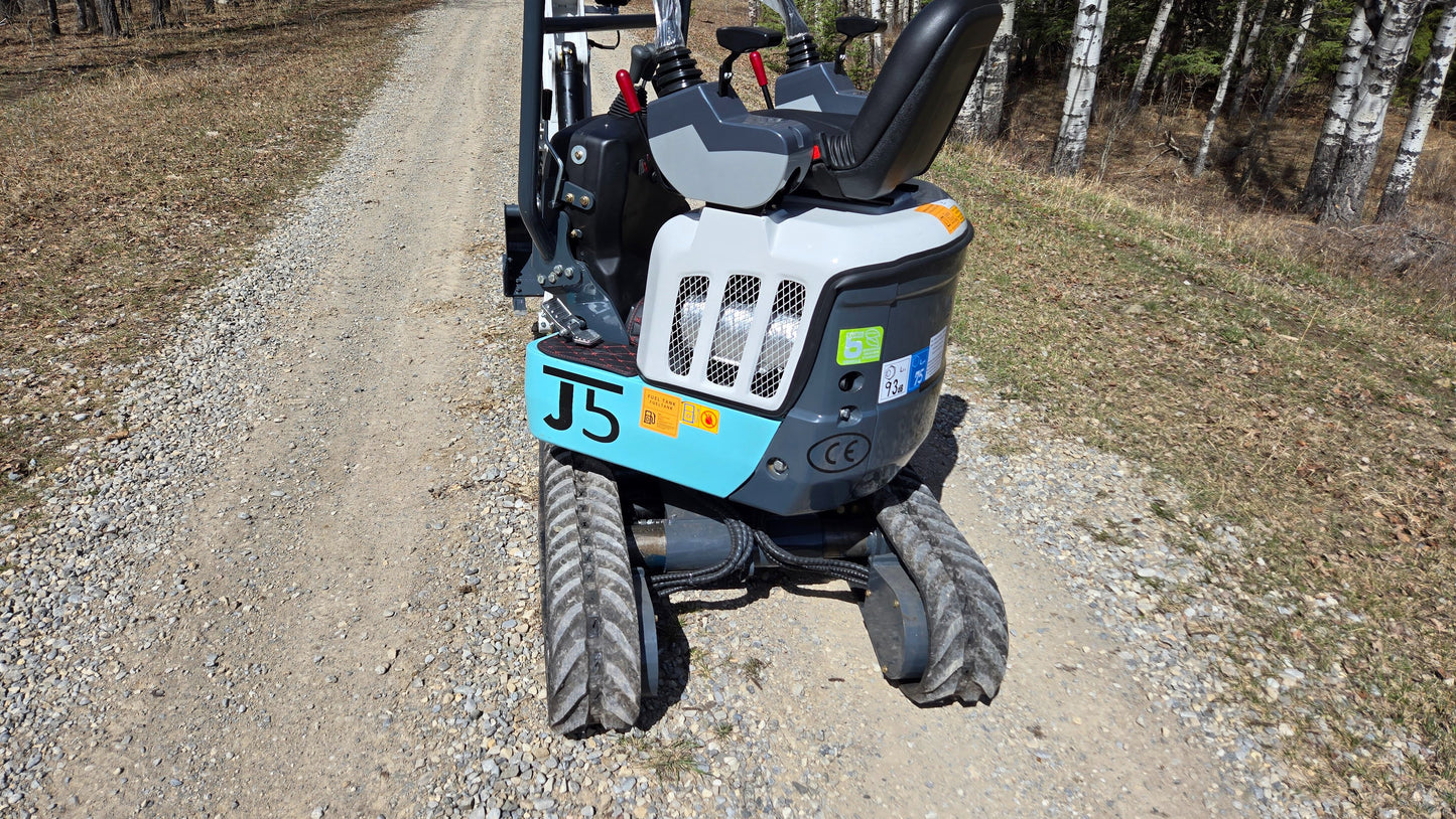 JT5120P 1.2 Ton mini excavator close-up rear view showing operator seat, hydraulic controls, engine cover, and durable rubber tracks for compact construction use.
