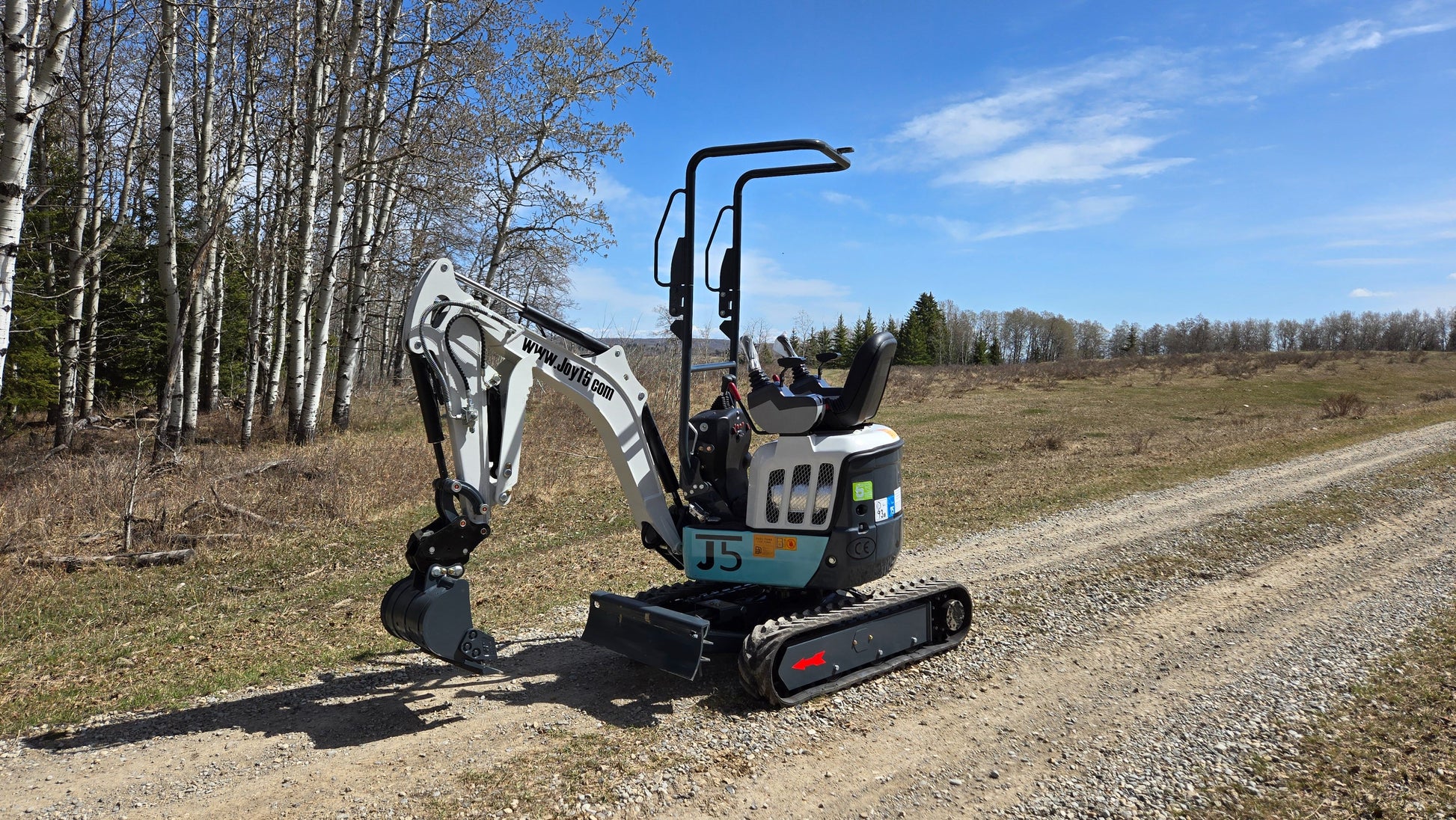 JT5120P 1.2 Ton mini excavator side view with Kubota D722 engine, pilot controls, and front blade down. Compact zero tail swing design for trenching, landscaping, and small construction projects.
