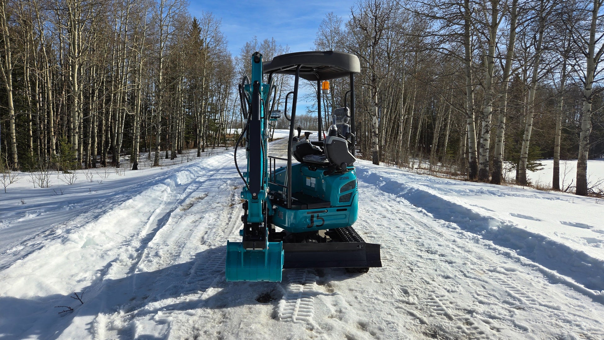 Front view of JoyT5 JT5200 2 ton mini excavator with bucket lowered. Compact construction equipment designed for trenching, landscaping, utility work, and small-scale excavation projects.
