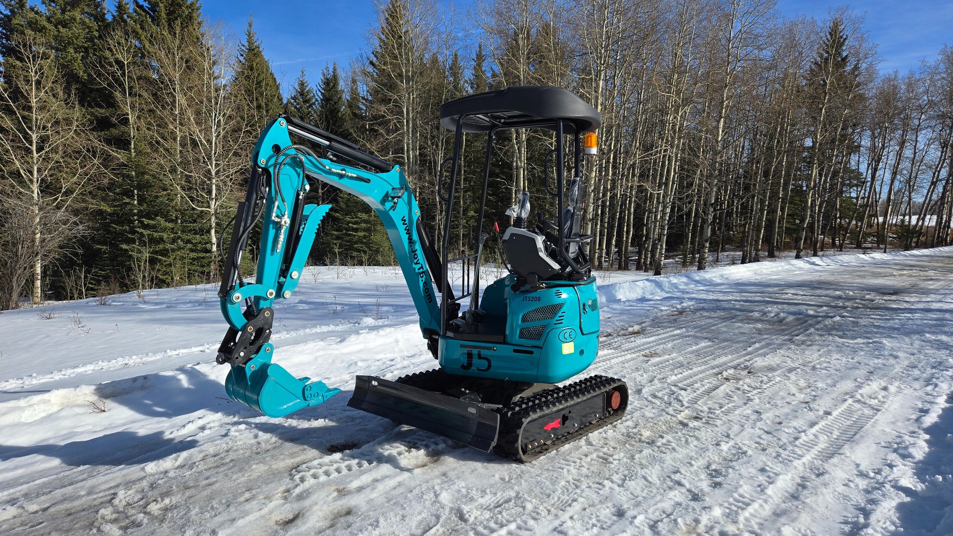 Rear-side angle view of JoyT5 JT5200 2 ton mini excavator with digging arm extended and bucket lowered. Compact excavator ideal for construction, trenching, landscaping, and utility work.
