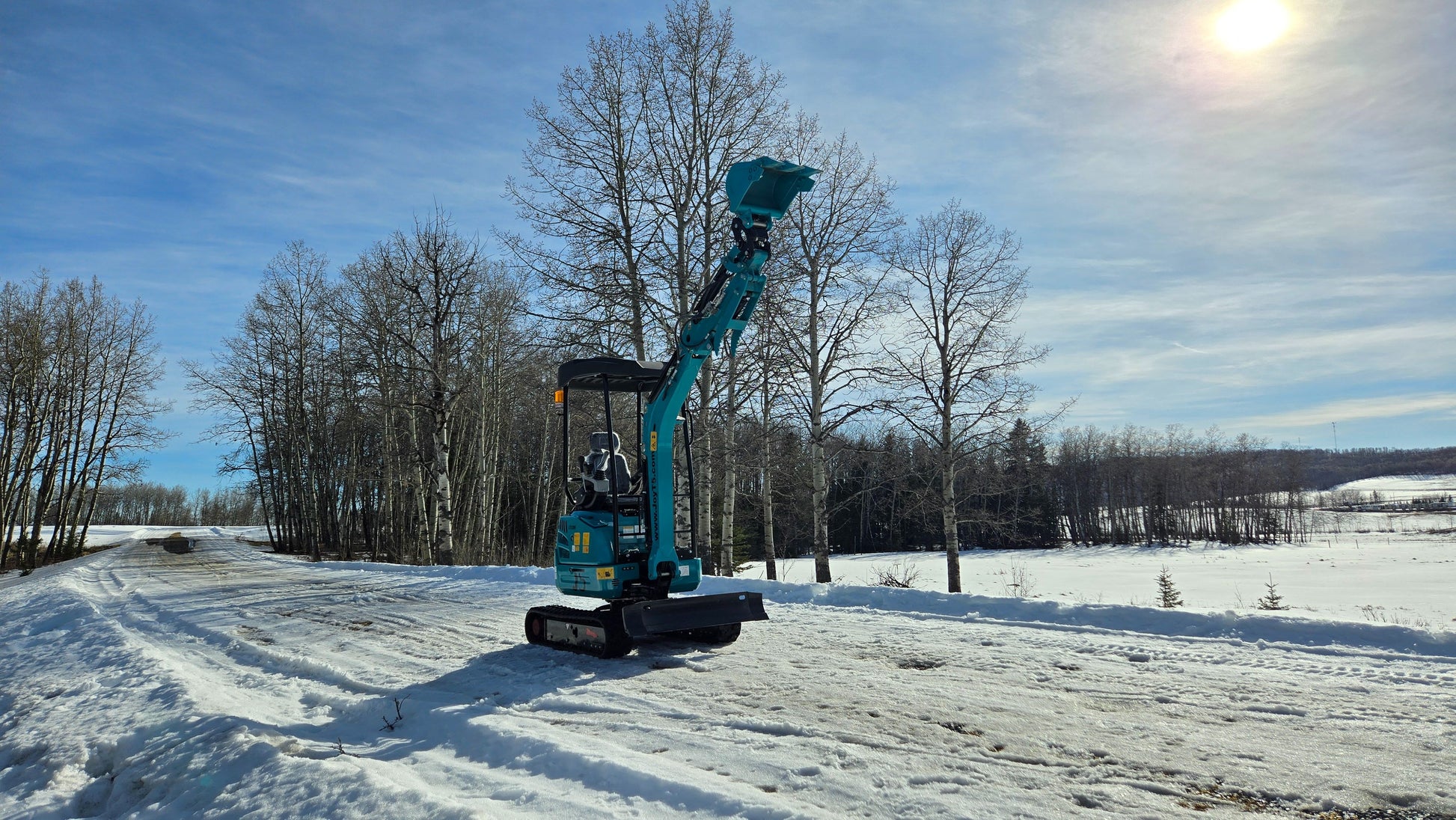 Rear view of JoyT5 JT5200 2 ton mini excavator with boom raised. Compact Kubota-powered excavator featuring zero-tail, hydraulic thumb, U-boom, side swing boom and extendable undercarriage for landscaping and construction.
