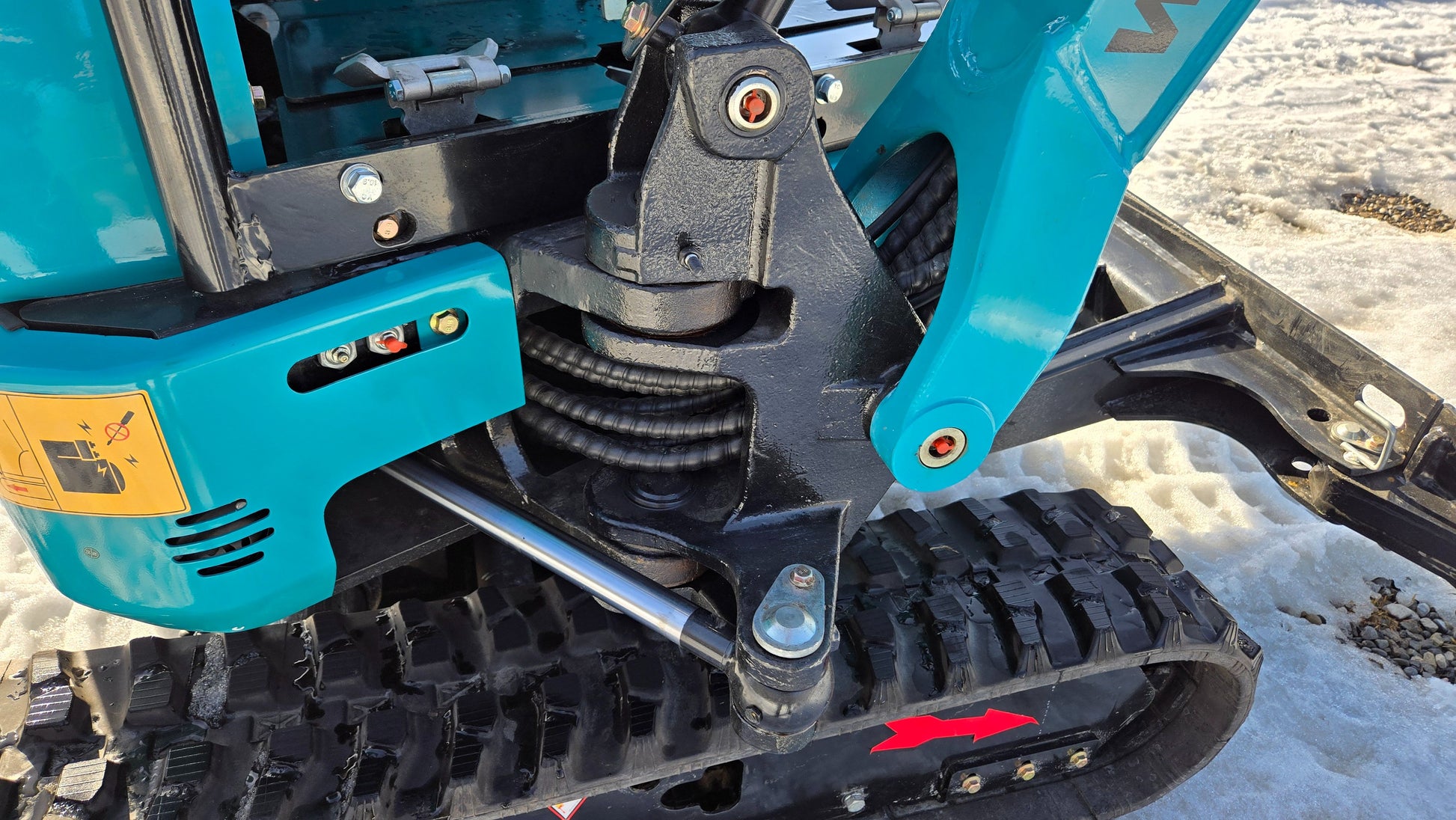Close-up of JoyT5 JT5200 mini excavator boom pivot with hydraulic cylinder and rubber track for stable and precise digging.

