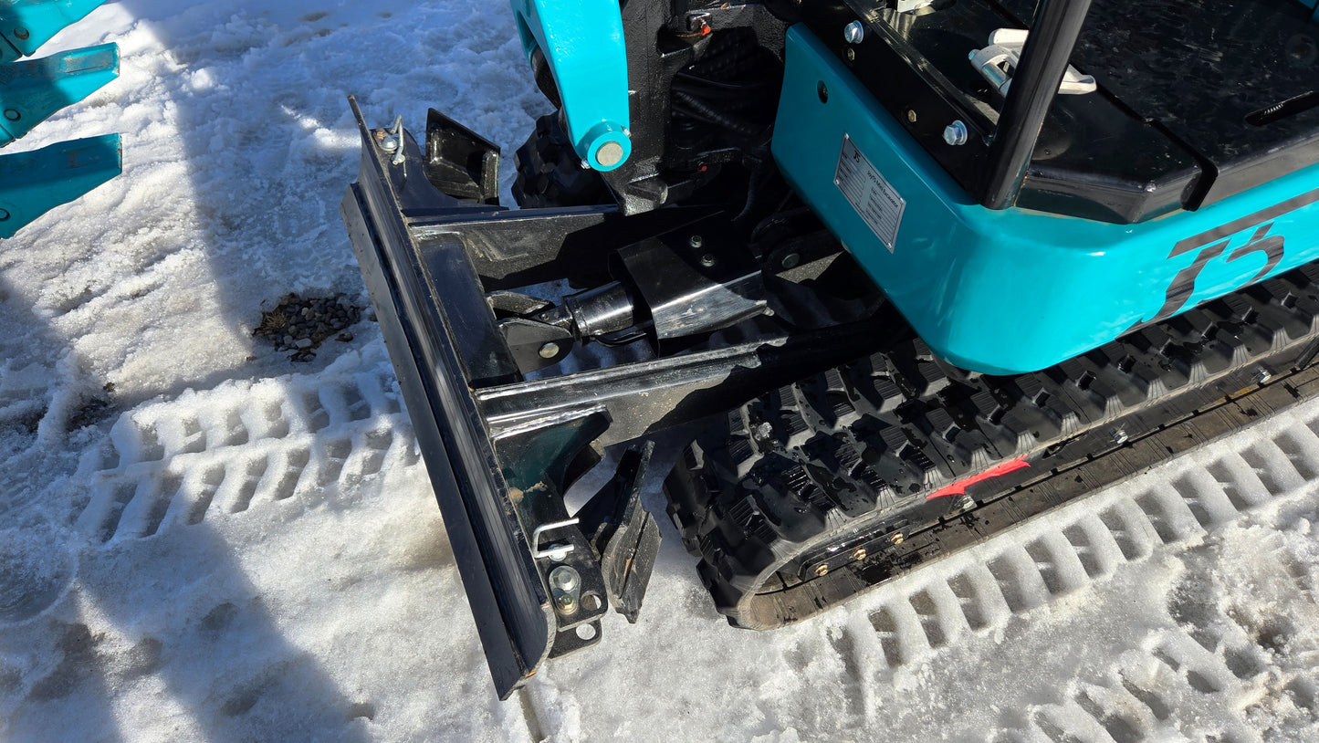 Rear side view of JoyT5 JT5200 mini excavator dozer blade and rubber track system on snow-covered ground.

