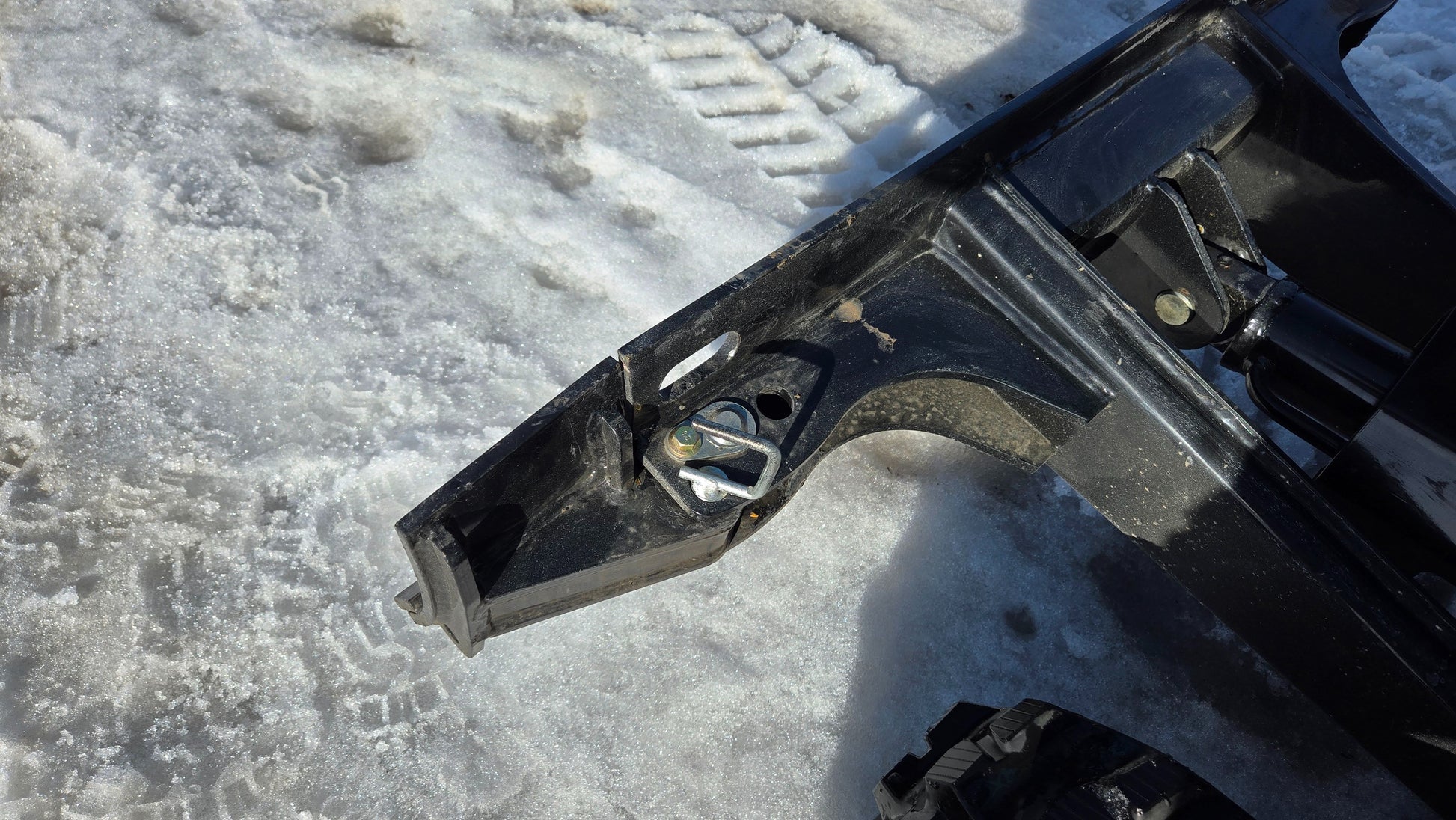Close-up of JoyT5 JT5200 mini excavator dozer blade mounting bracket with safety lock pin for secure blade attachment.
