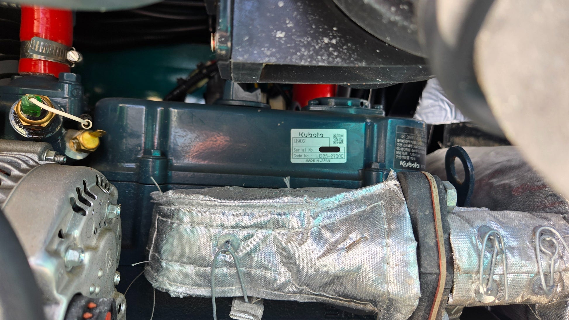 Close-up of Kubota D902 engine inside JoyT5 JT5200 mini excavator, showing engine label and surrounding components.
