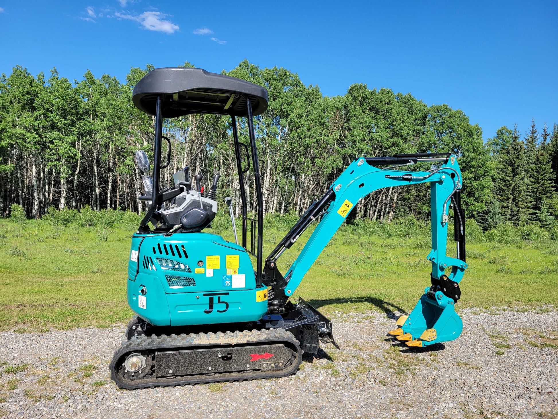 JT5200 blue mini excavator side view, showing compact body, operator seat, and digging arm design for small construction and landscaping tasks.
