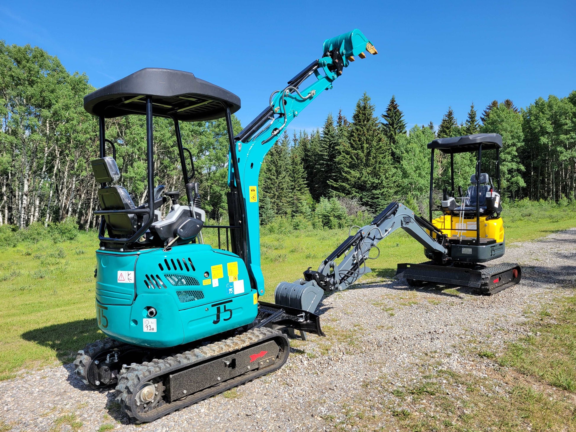 Close-up view of JT5200 mini excavators in blue and yellow, showing boom movement and compact design for small construction projects.
