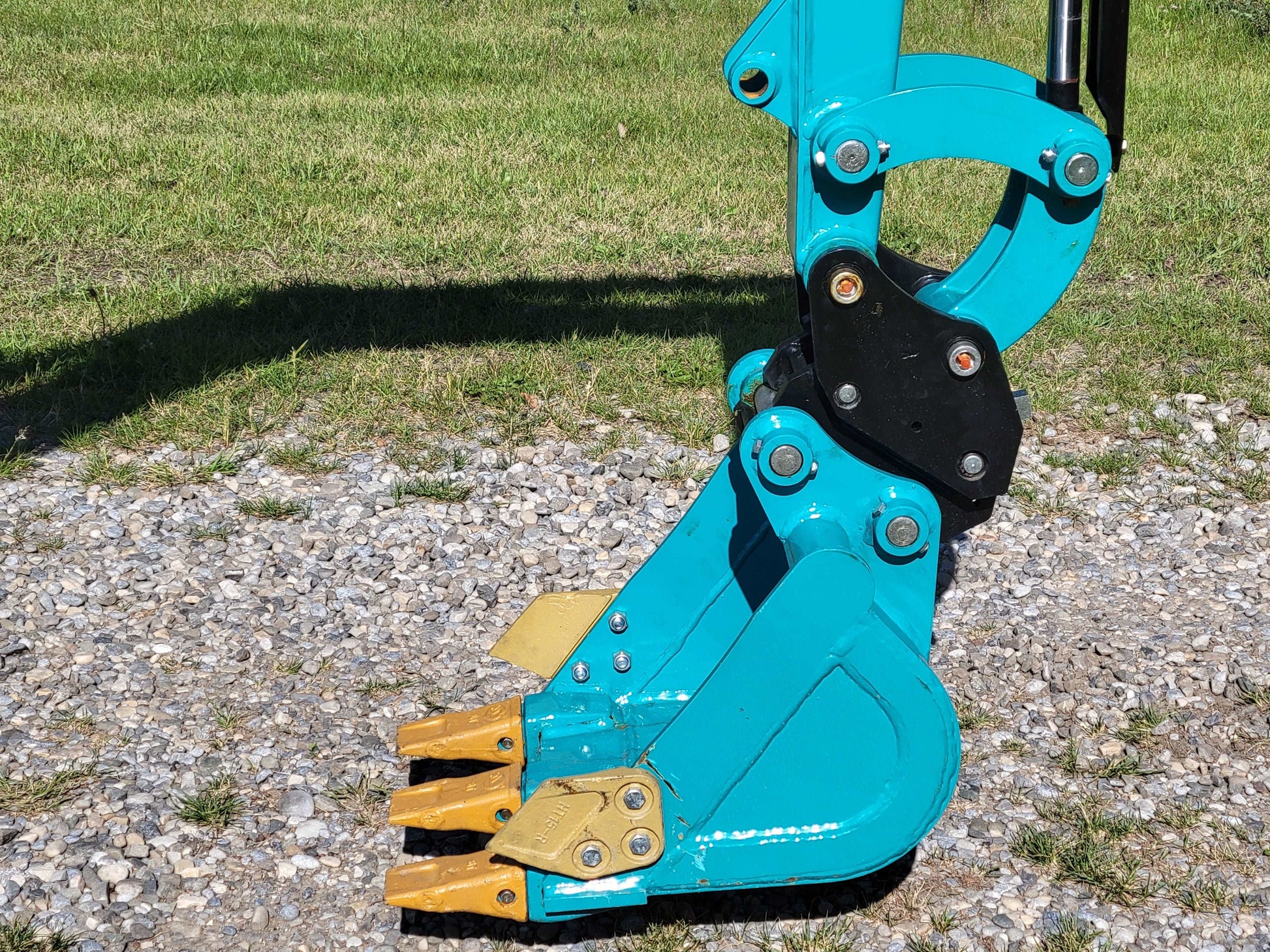 Close-up of JT5200 mini excavator digging bucket with reinforced teeth designed for efficient soil and gravel excavation.

