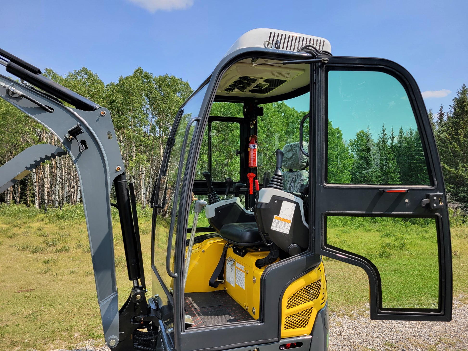 JT5200 Special Edition 2 Ton Mini Excavator cab interior with operator seat, dual joystick controls, fire extinguisher and comfort features. Compact 4400 lbs digger with Kubota engine for construction and landscaping.
