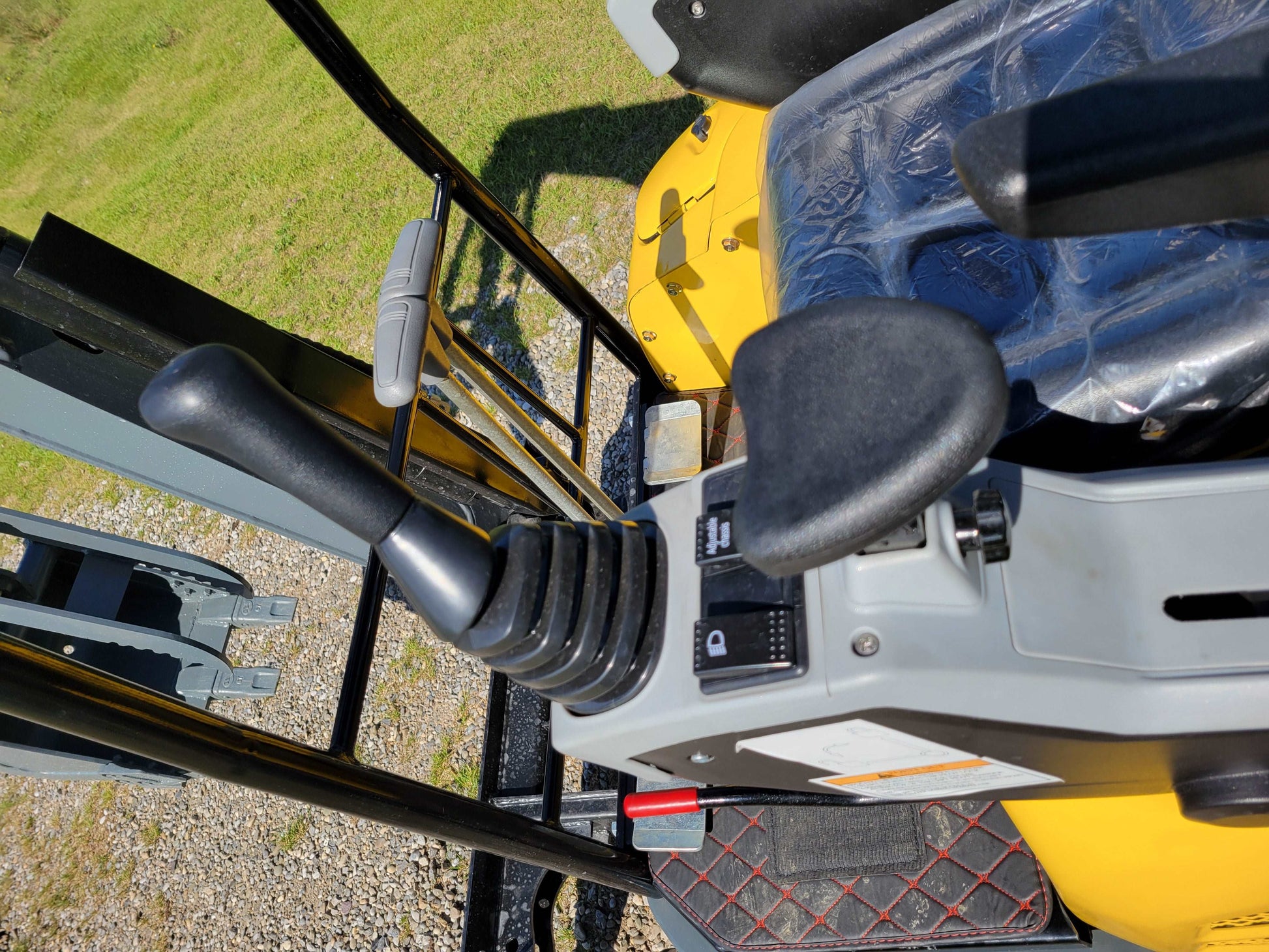 Close-up view of JT5200 mini excavator control joystick, armrest, and operator seat area.
