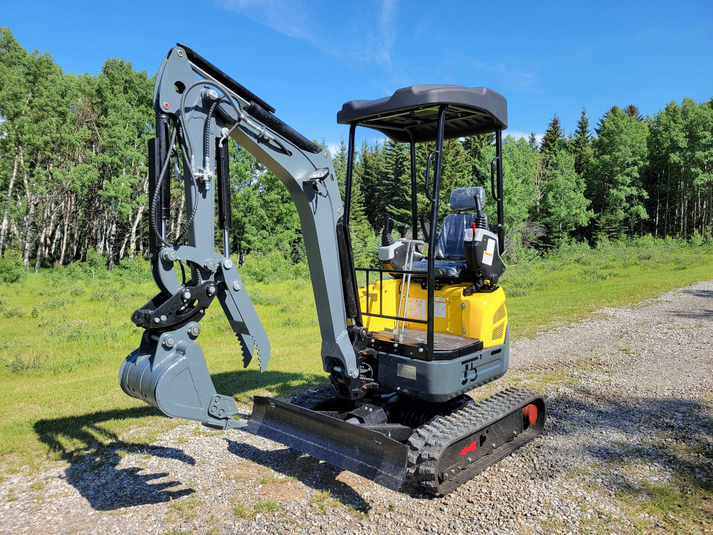 Front right angle view of JT5200 mini excavator with digging bucket, dozer blade, and operator seat.
