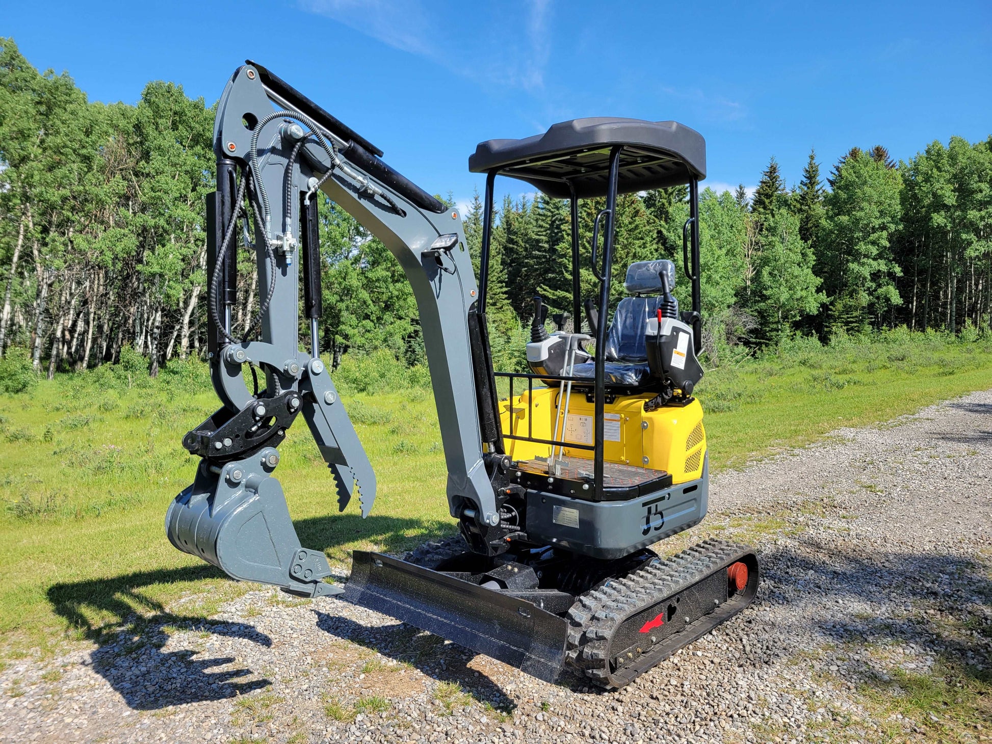 Front right angle view of JT5200 mini excavator with digging bucket, dozer blade, and operator seat.
