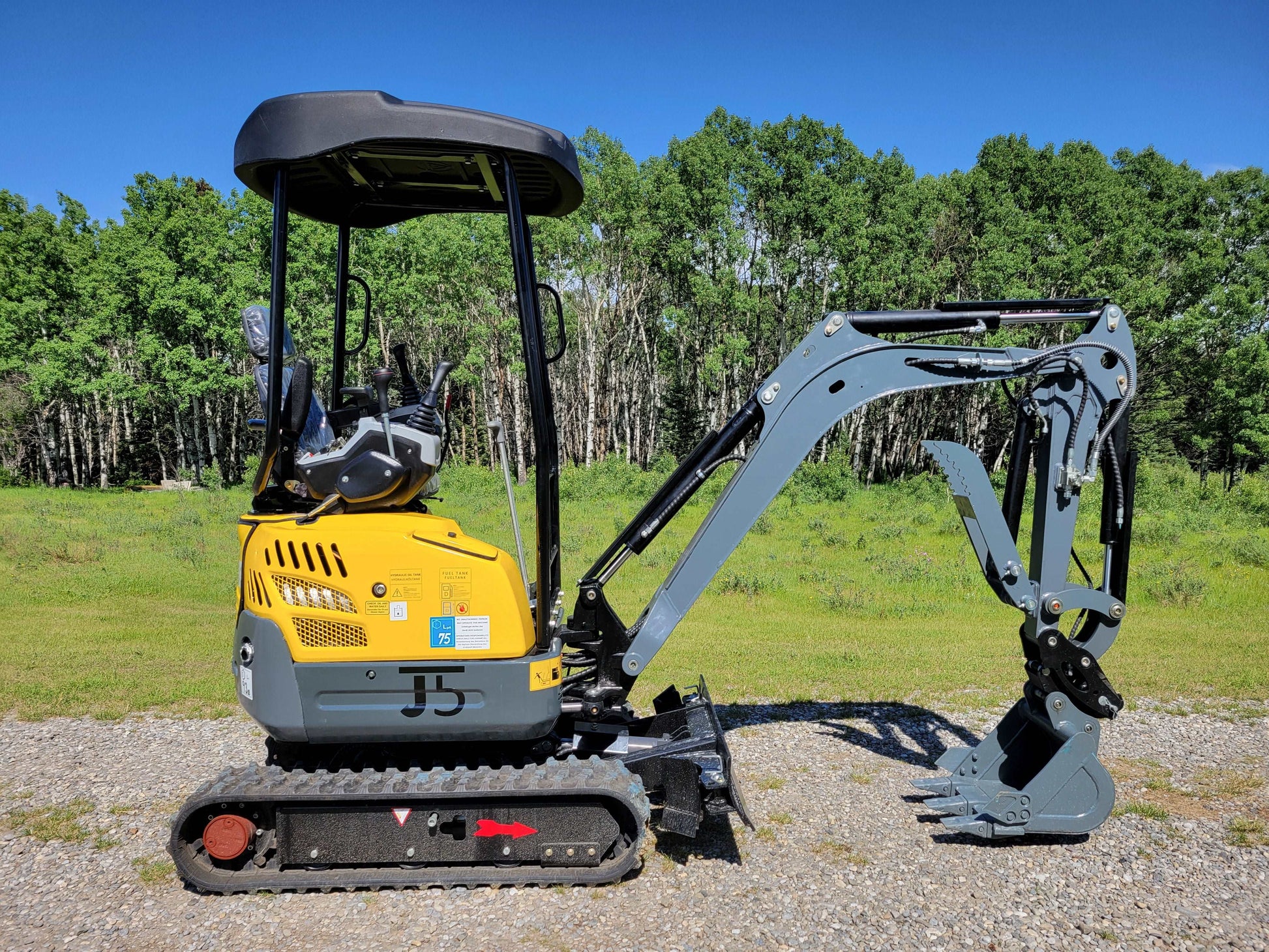 JoyT5 JT5200 mini excavator full side view showing operator cabin, rubber tracks, hydraulic arm, and digging bucket.
