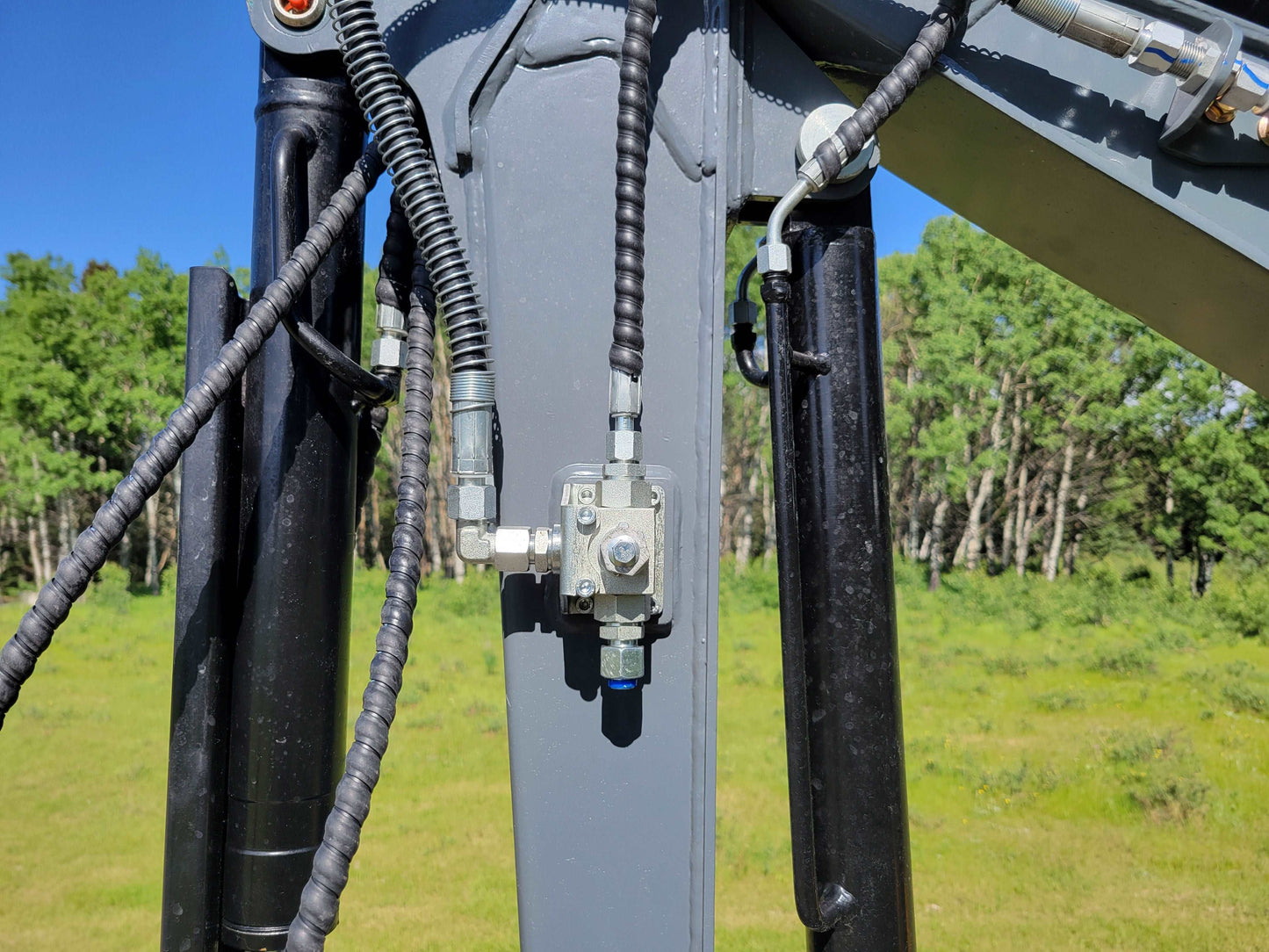 Close-up of JT5200 mini excavator hydraulic valve with hose connections and fittings.
