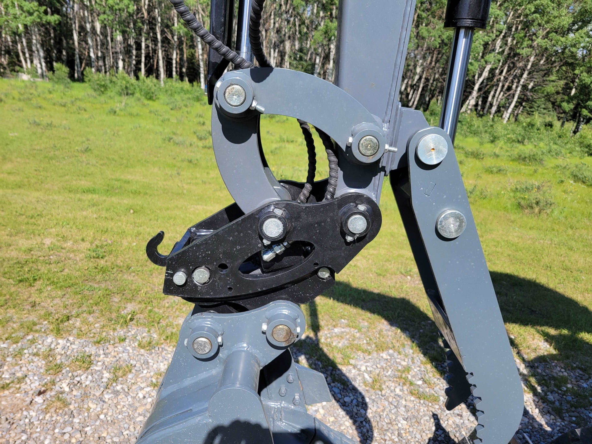 Close-up of JT5200 mini excavator quick coupler mechanism for bucket attachment.
