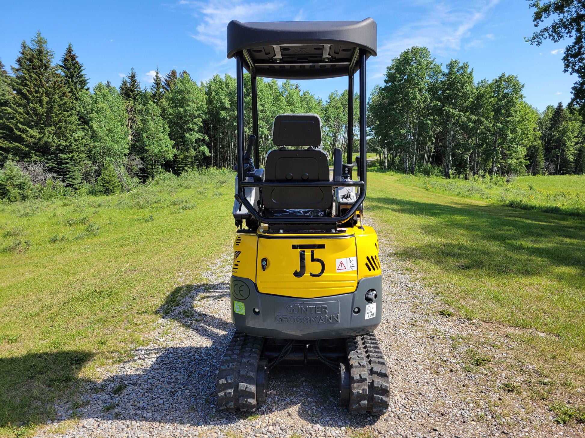 JoyT5 JT5200 mini excavator rear view showing operator seat, canopy, rubber tracks, and engine cover.
