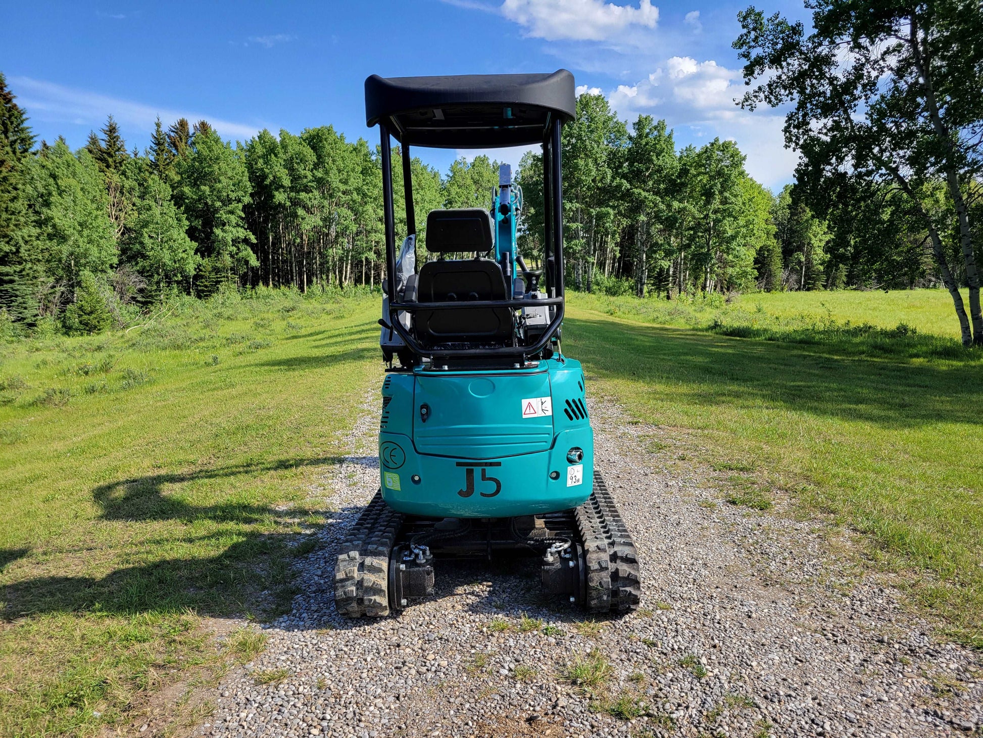 Rear view of JT5200 mini excavator showing operator seat, safety frame, and rubber tracks.
