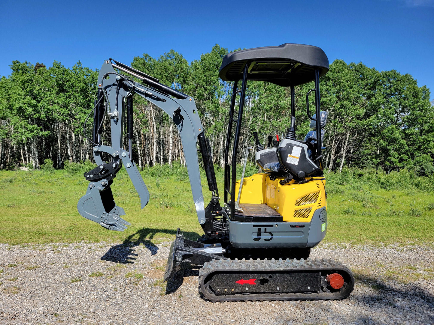 Right side view of JT5200 mini excavator with digging arm, bucket, and rubber tracks on gravel.
