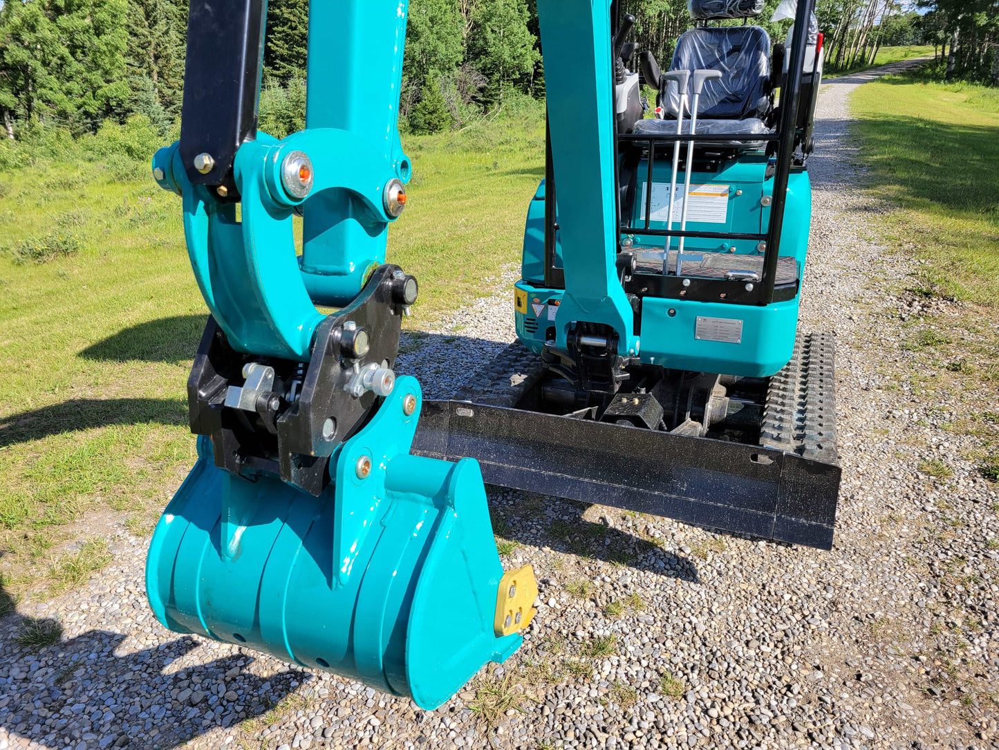 Close-up view of JT5200 mini excavator bucket and operator seat with joystick controls.
