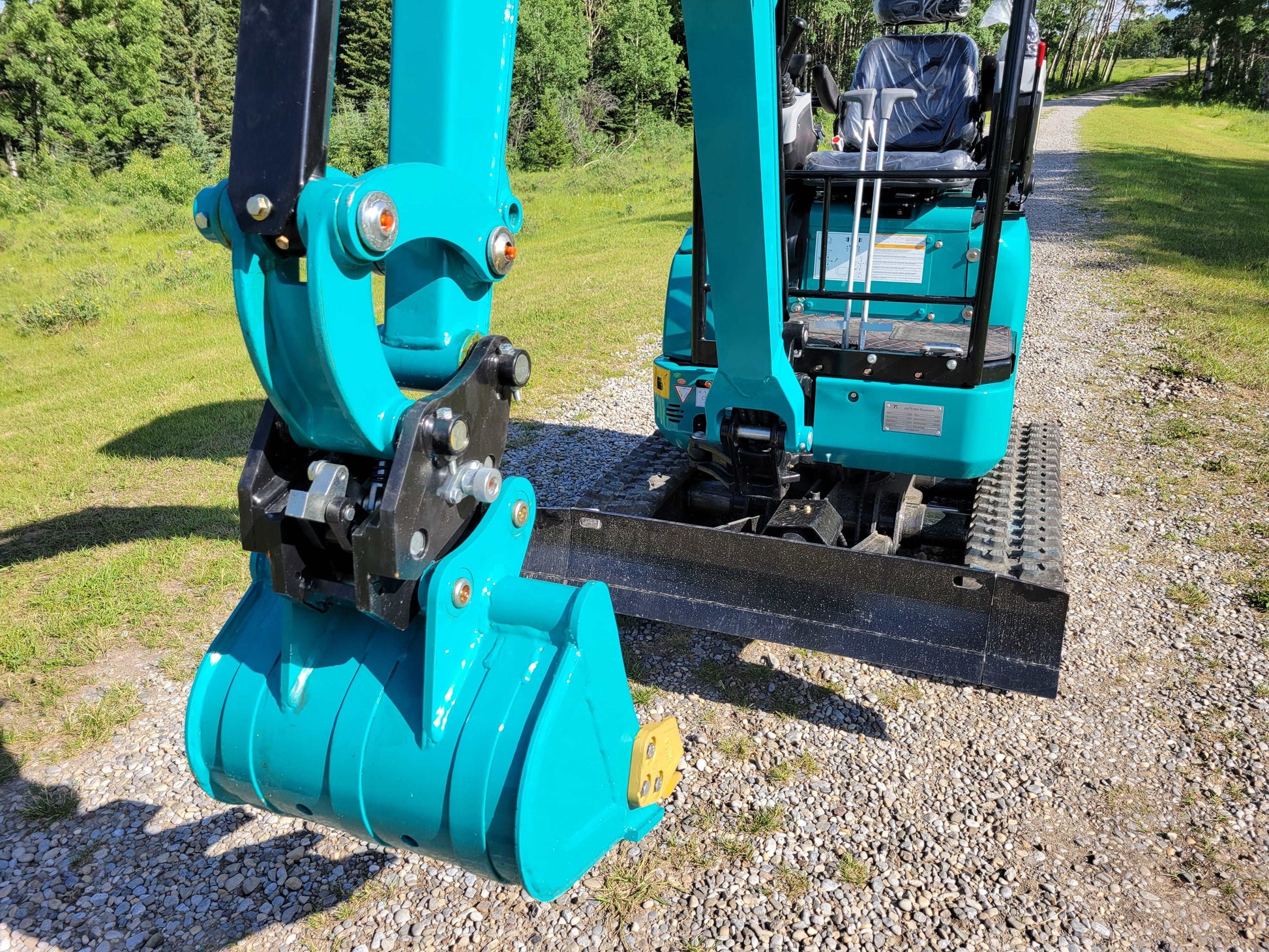 Close-up view of JT5200 mini excavator bucket and operator seat with joystick controls.
