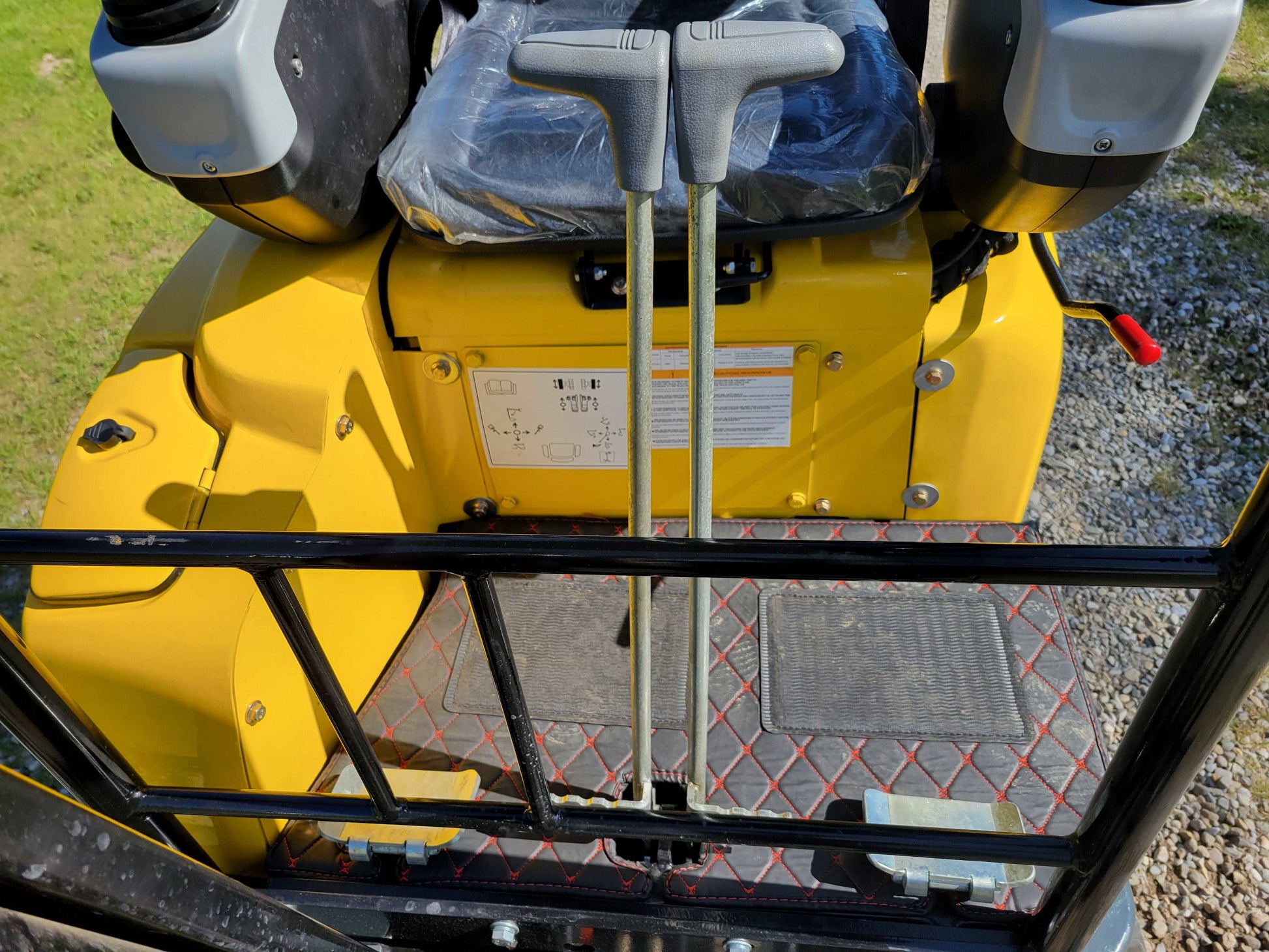 JT5200 mini excavator floor area with dual travel control levers and protective floor mat.

